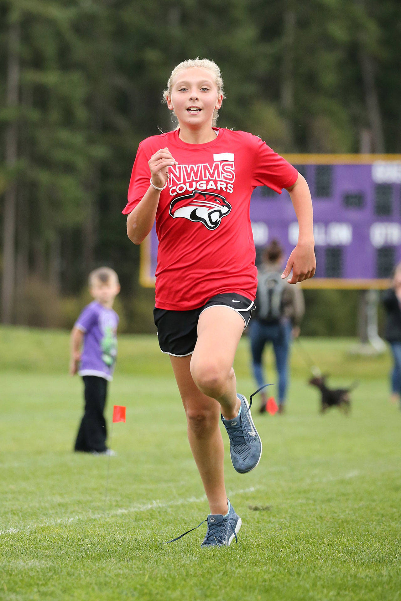 North Whidbey Middle School’s Addisen Boyer hustles to the finish line in first place in the seventh-grade girls race.(Photo by John Fisken)