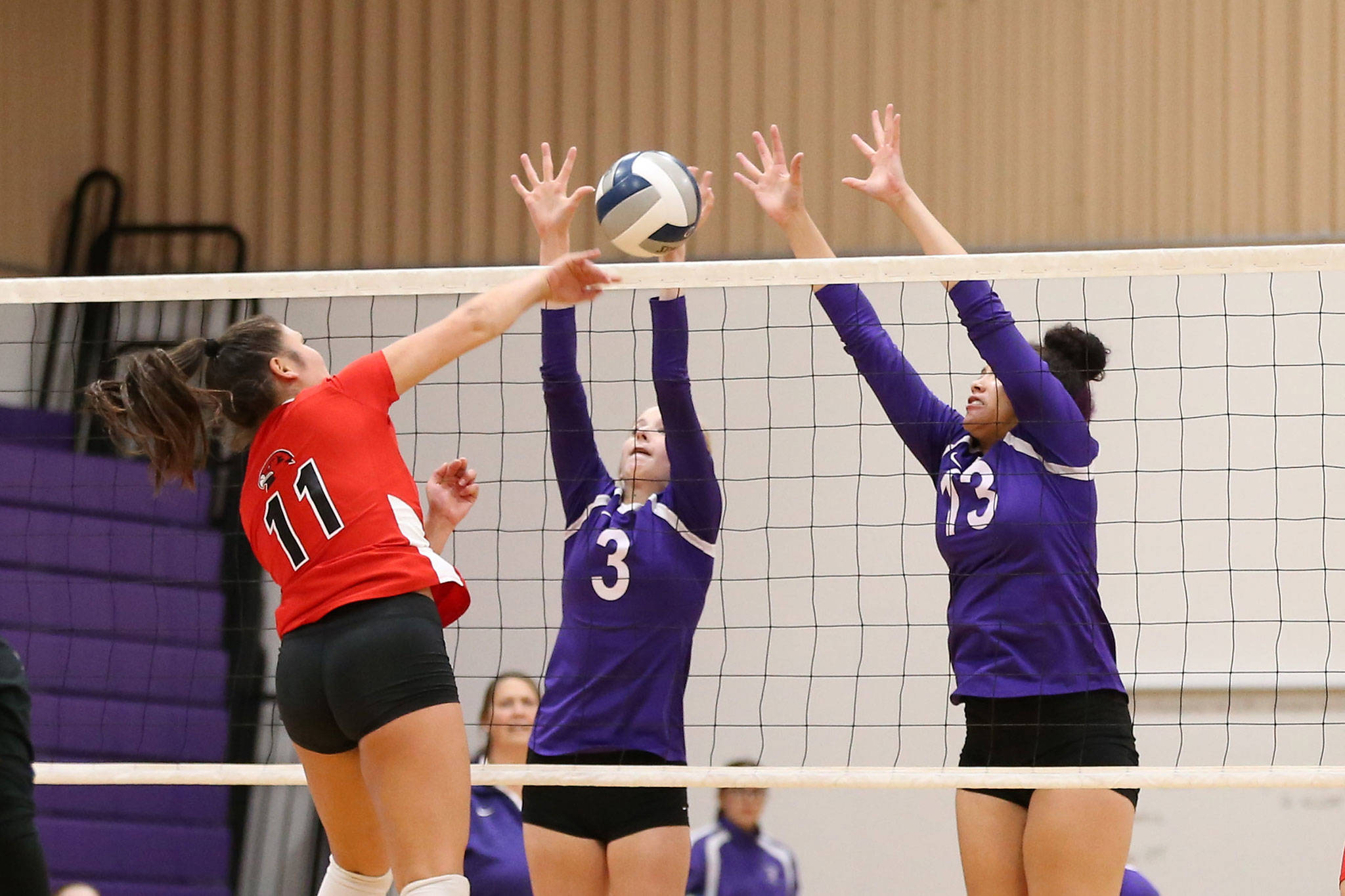Lacey Zylstra (3) blocks a hit by Mountlake Terraces Kiana Hickley as Jasmine Ford (13) reaches to help.(Photo by John Fisken)