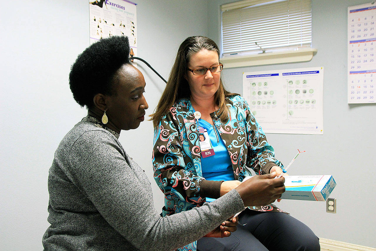 Penny Macharia, left, and Stacia Ott talk about women’s health care and contraceptives options. Photo by Laura Guido/Whidbey News-Times