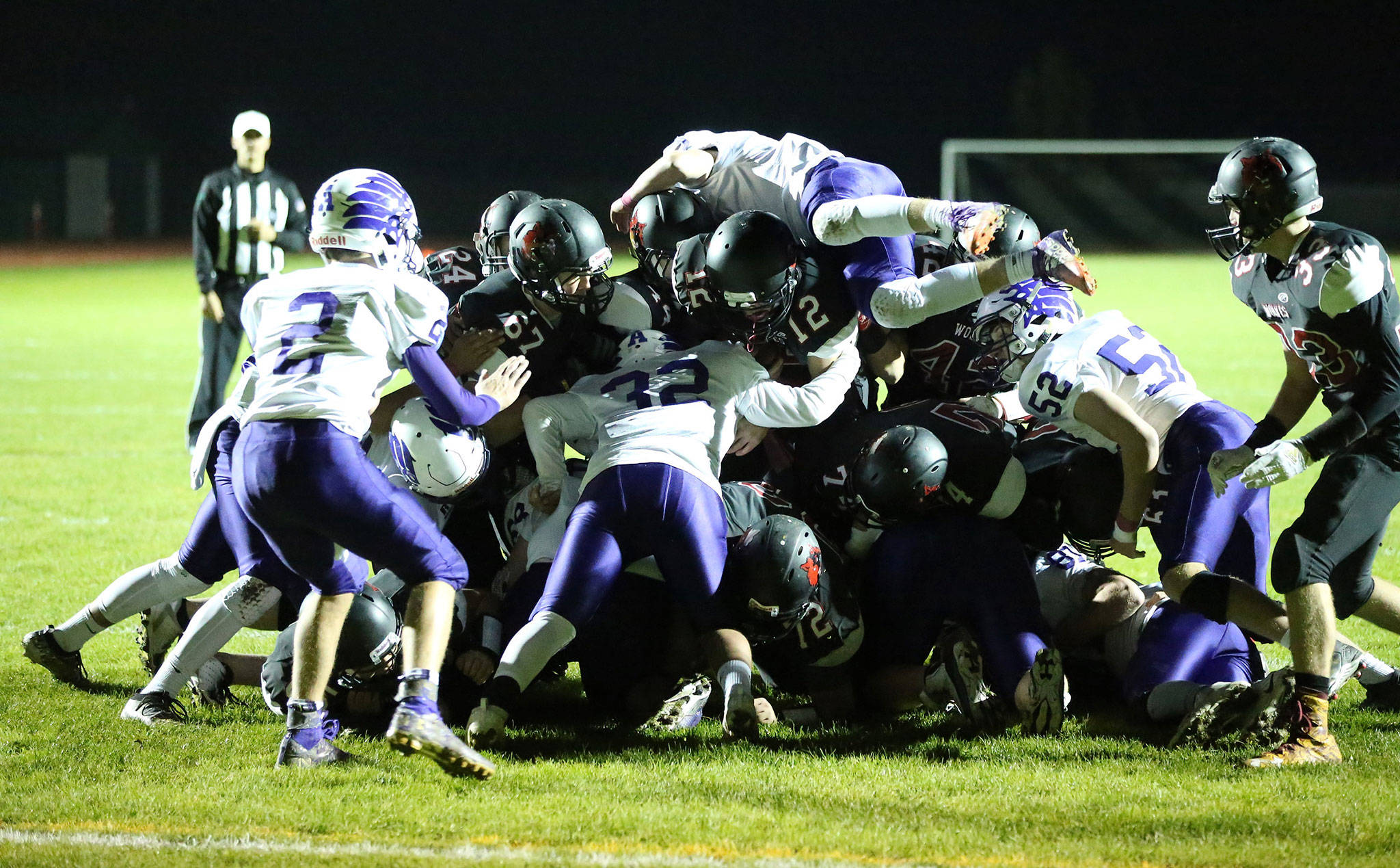 Coupeville quarterback Dawson Houston (12) and the Wolves bull ahead on a quarterback sneak Friday against Anacortes. (Photo by John Fisken)