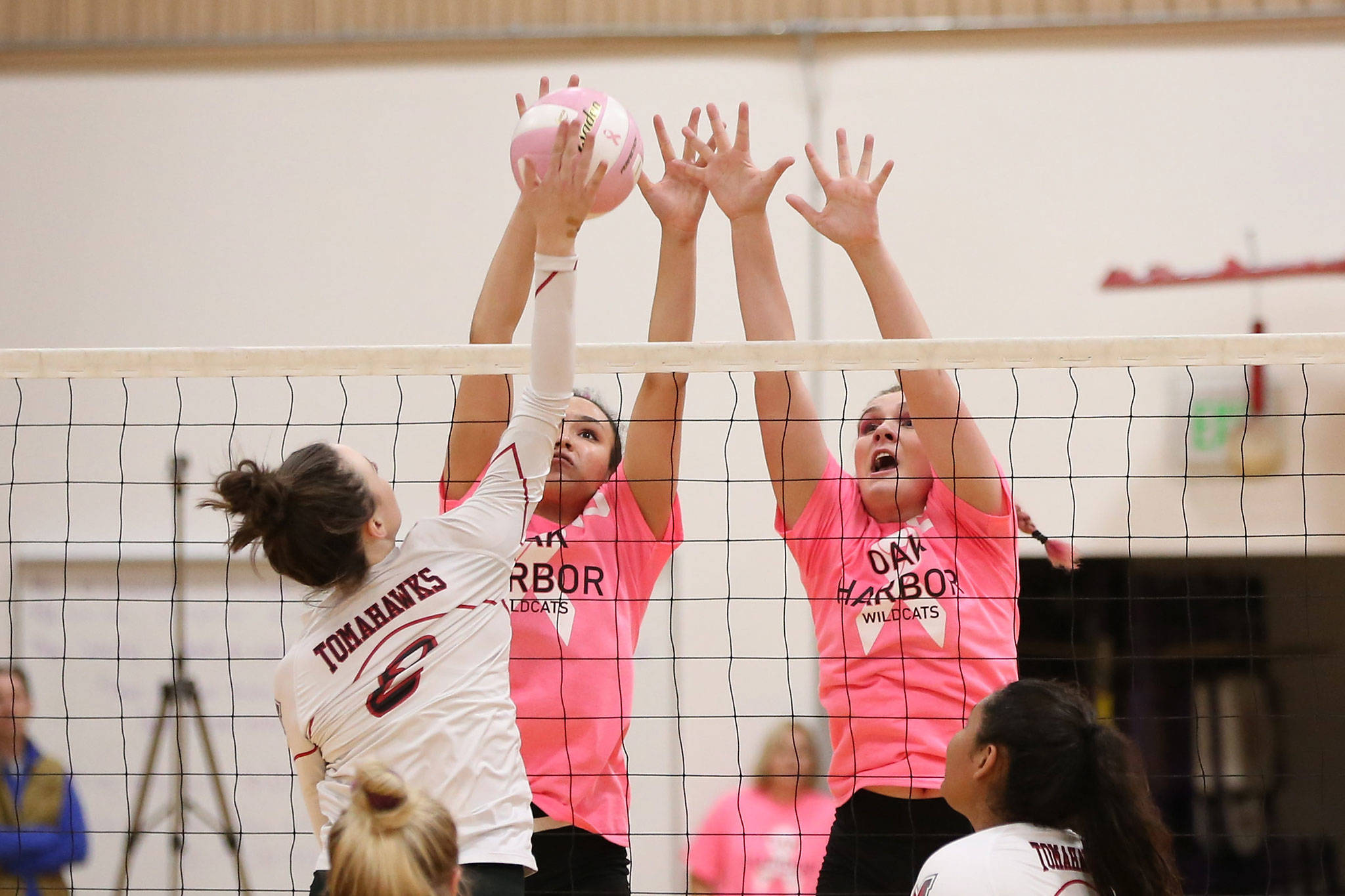 Oak Harbor’s Jasmine Ford, left, and Payton Parks put up a block for the Wildcats. (Photo by John Fisken)