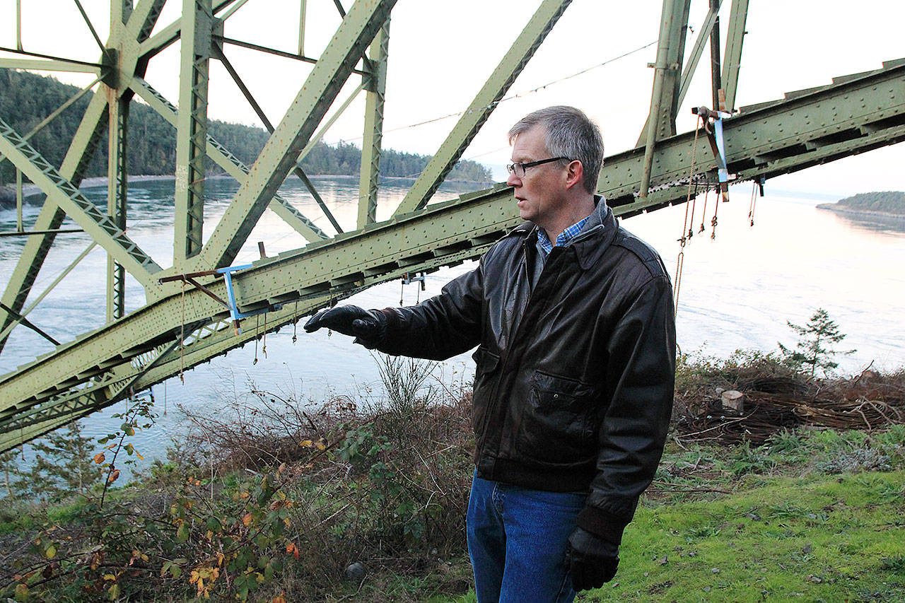 State Rep. Dave Paul, D-Oak Harbor, stands under Deception Pass Bridge Wednesday morning and explains its importance. Photo by Laura Guido/Whidbey News-Times