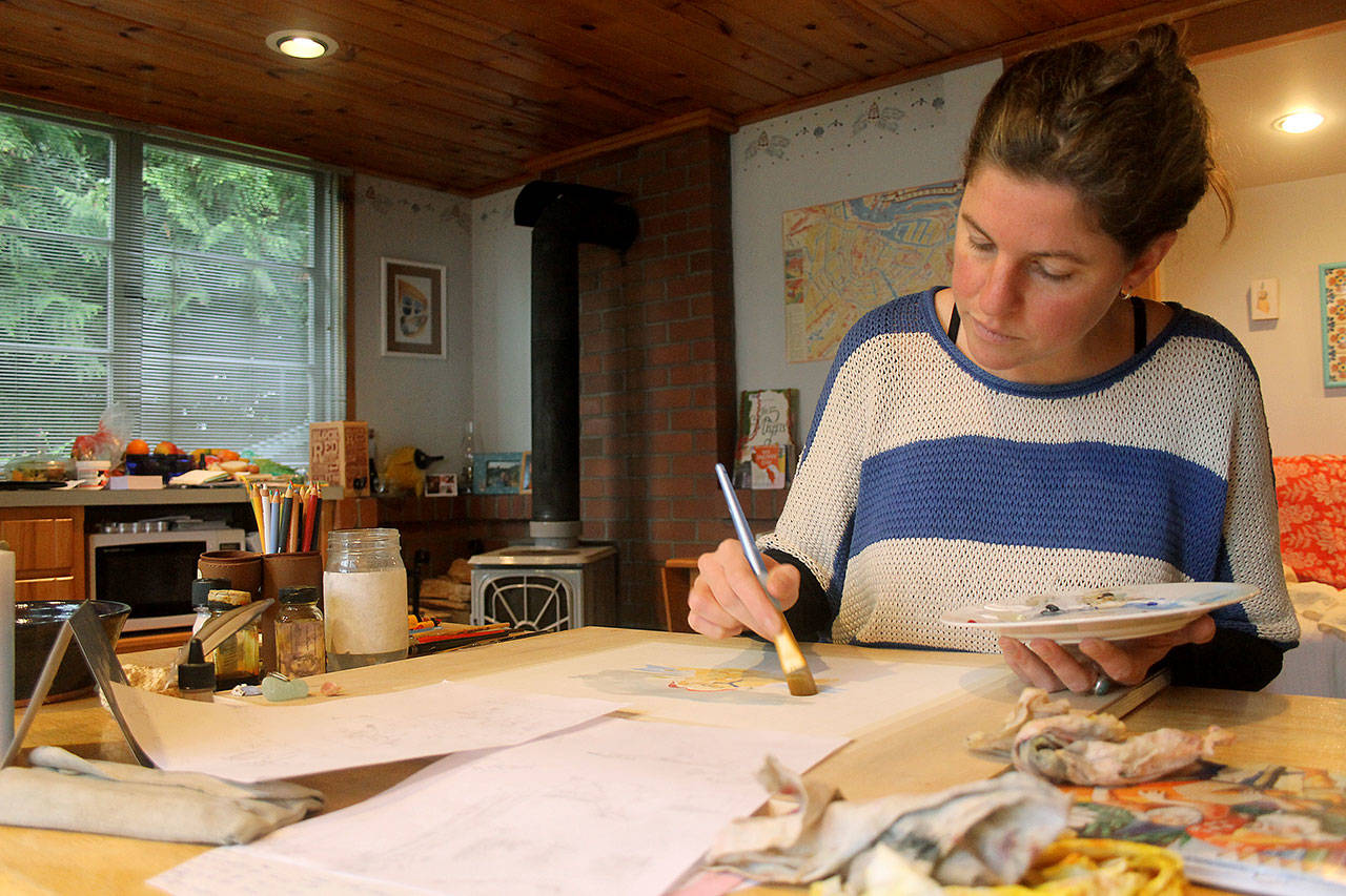 Photo by Kira Erickson /Whidbey News Group                                Anna Cosper paints a design for a commissioned holiday card in her studio.
