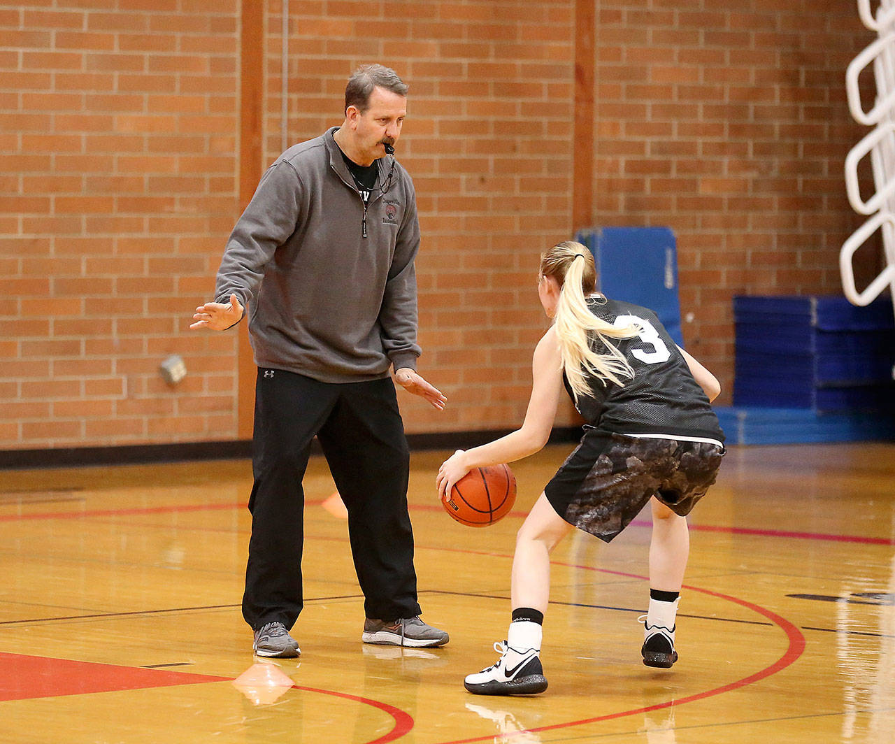 New Coupeville coach Scott Fox helps out in a drill during practice Tuesday. (Photo by John Fisken)