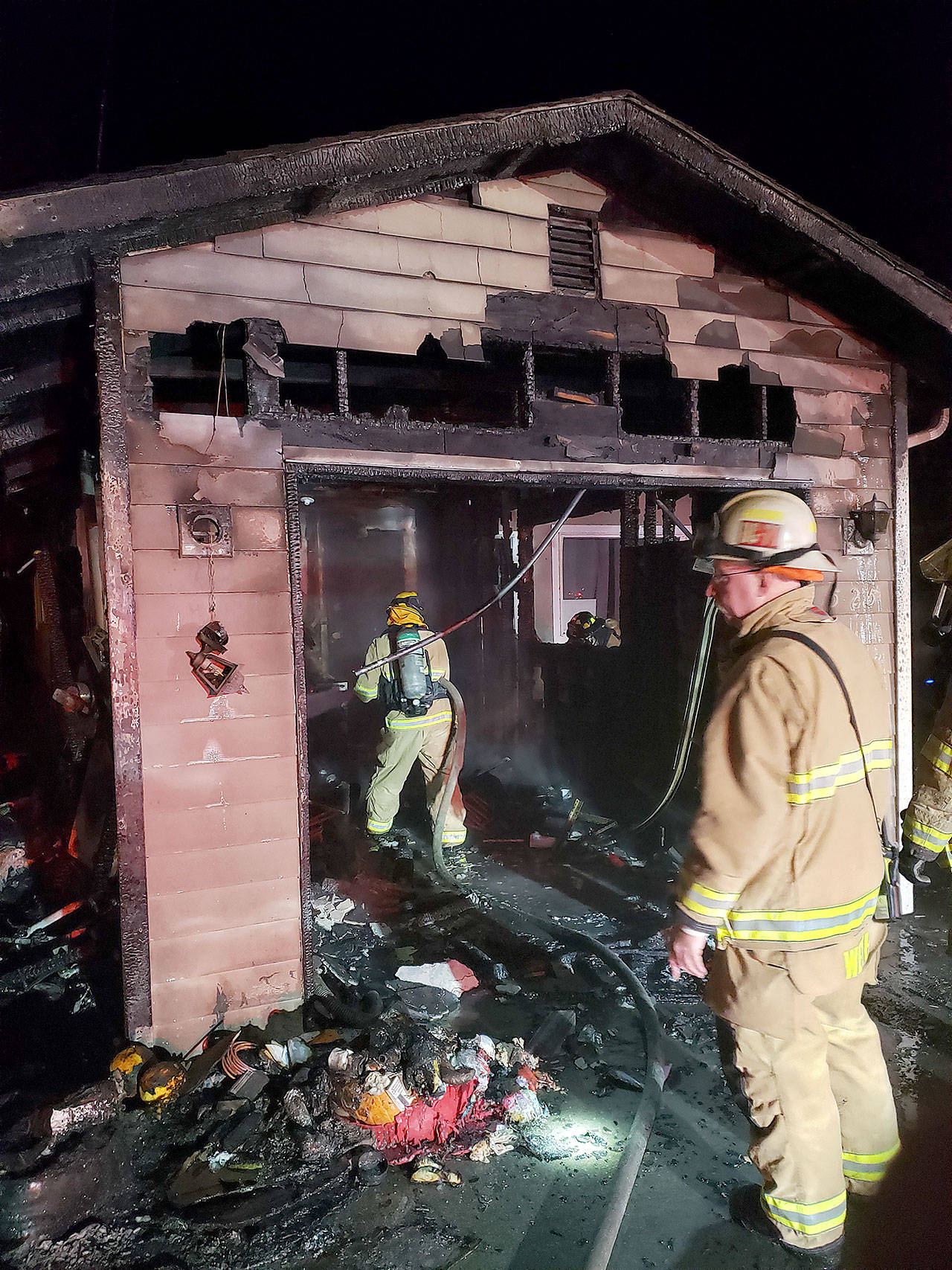Firefighters work on a garage fire Saturday night on North Whidbey. Photo provided by North Whidbey Fire and Rescue