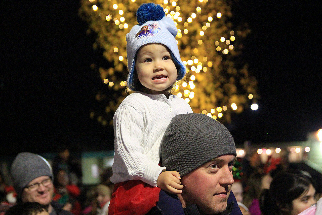 Laila Thomas, 2, reacts to the giant tree in downtown Oak Harbor being lit Saturday night by Santa and Mayor Bob Severns. Photos by Laura Guido/Whidbey News-Times