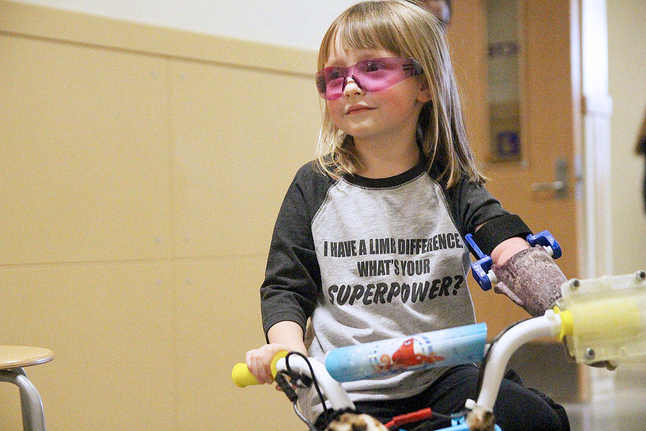 Four-year-old Michaela Reed sails through a hallway at Oak Harbor High School on a bike designed for her by the Wildcat robotics team. File photo by Laura Guido/Whidbey News-Times