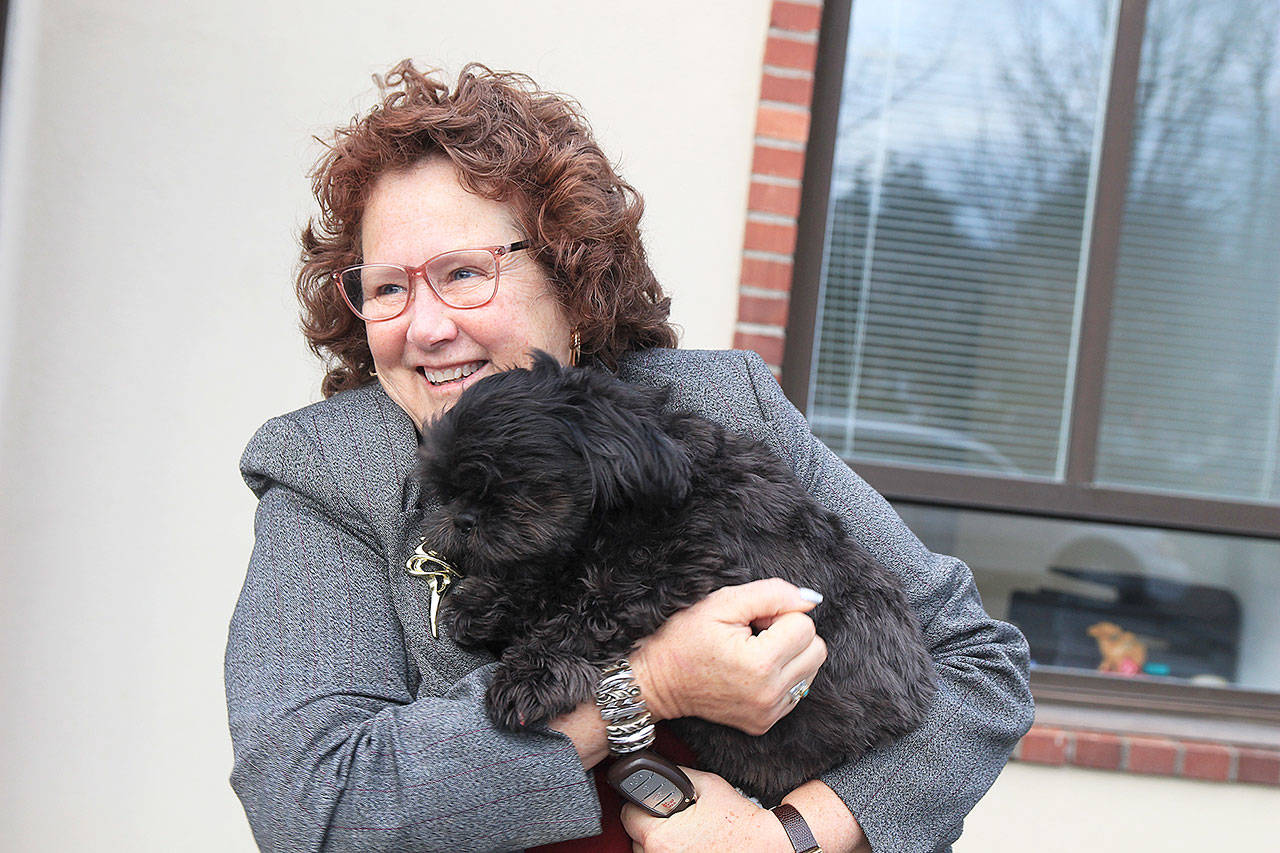 Photo by Laura Guido/Whidbey News-Times                                Island County Commissioner Janet St. Clair snuggles with her dog Bogey outside the commissioners’ offices in Coupeville.