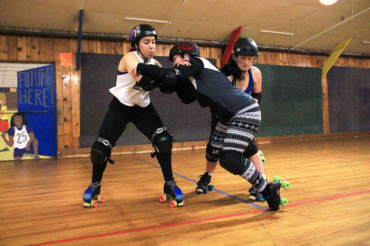 Photo by Laura Guido/Whidbey News-Times                                From left, Loanna “Freakin’ Rican” Delvillar, Nichole “Malice in Derbyland” Burton and Nicole “Kay Oss” O’Neill clash in a blocking drill at the Whidbey Island Roller Girls’ Thursday night practice.