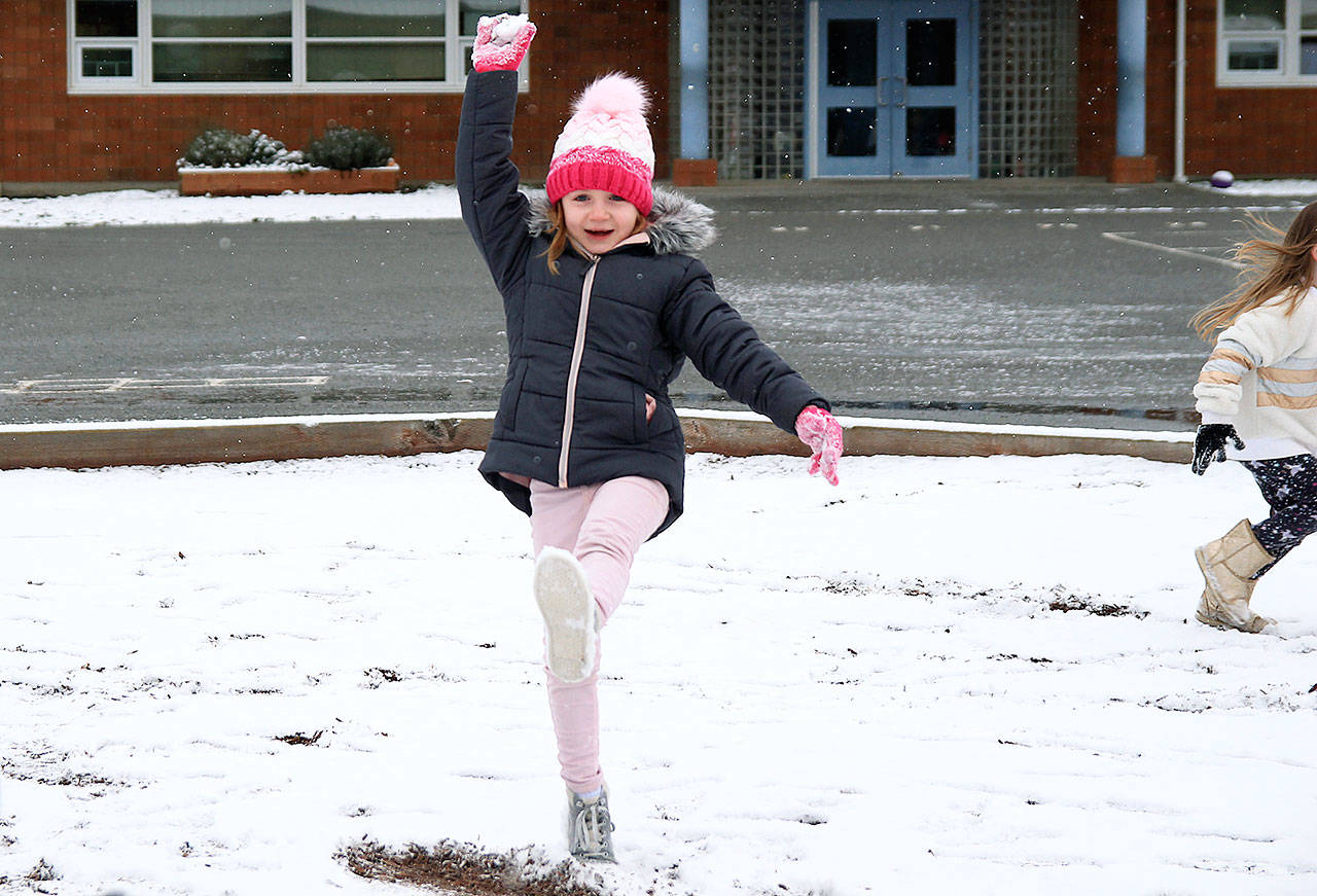 Aria Holbert hoists a snowball over her head during recess. She didn’t throw it at anyone.