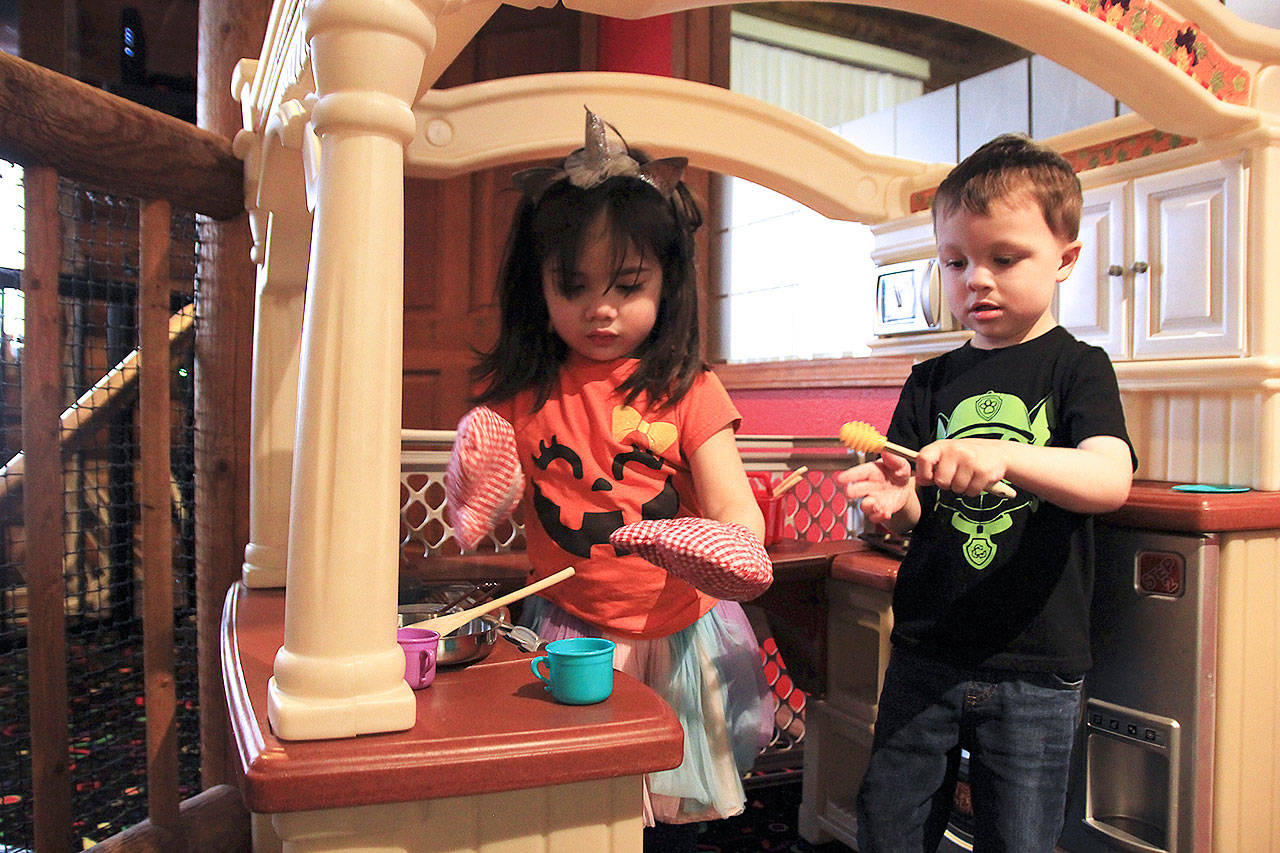Photo by Laura Guido/Whidbey News-Times                                Kara Pelzel, 3, and Ethan Boswell, 4, toil away in the kitchen space at Oak Harbor Playtown.