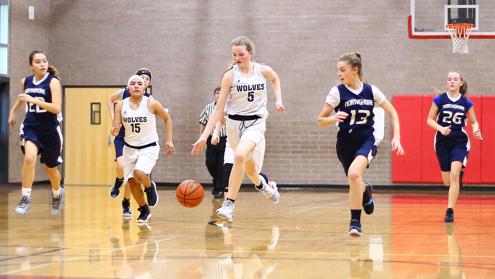 Couieville’s Savina Wells (5) leads a fast break while Desi Ramirez fills a lane.(Photo by John Fisken)