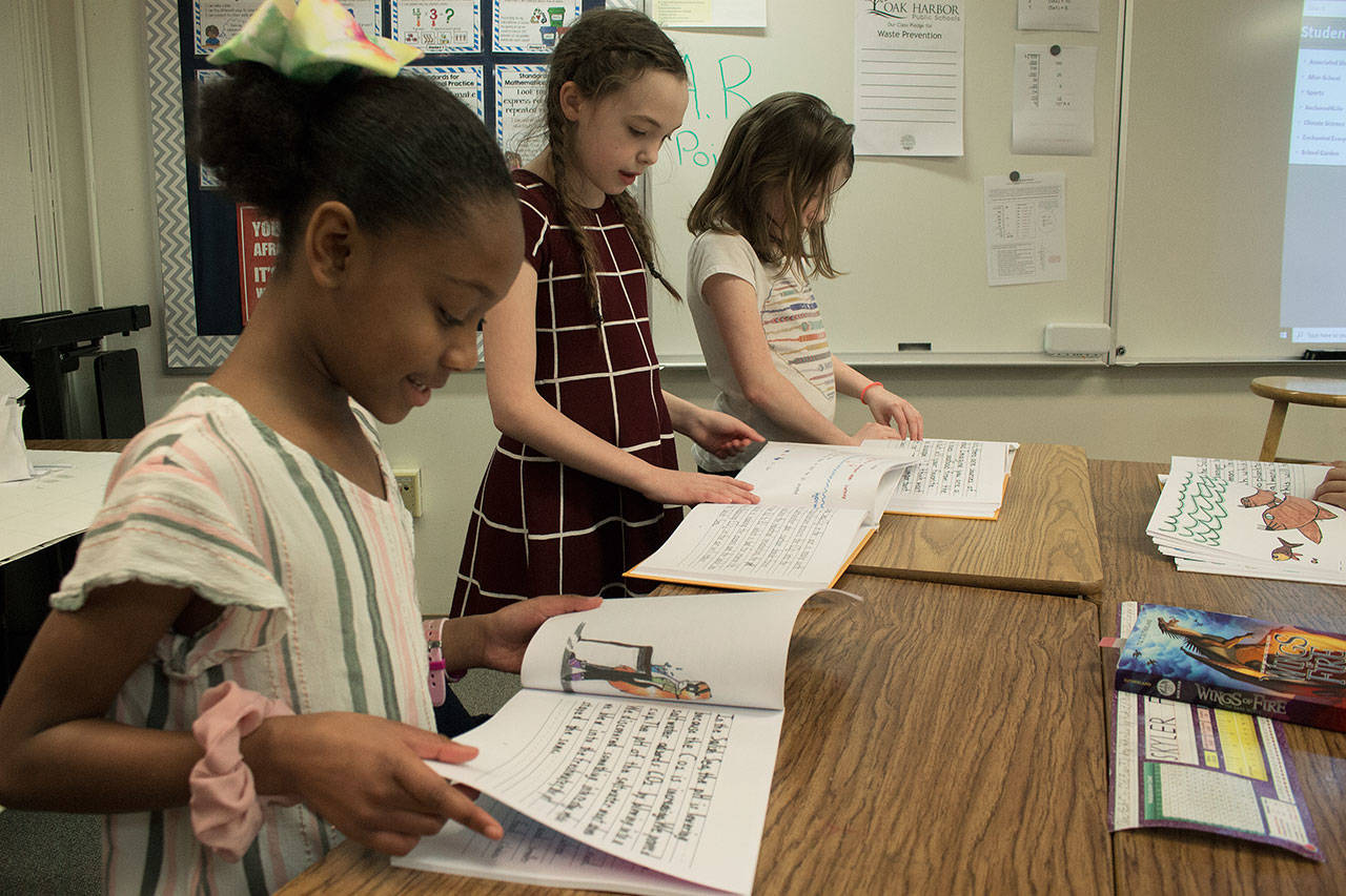 Photo by Brandon Taylor/Whidbey News-Times                                Arianna Watson, 9, Victoria Wiedrich, 9, and Avalee Wormwood, 9, worked on thee solutions section of the book.