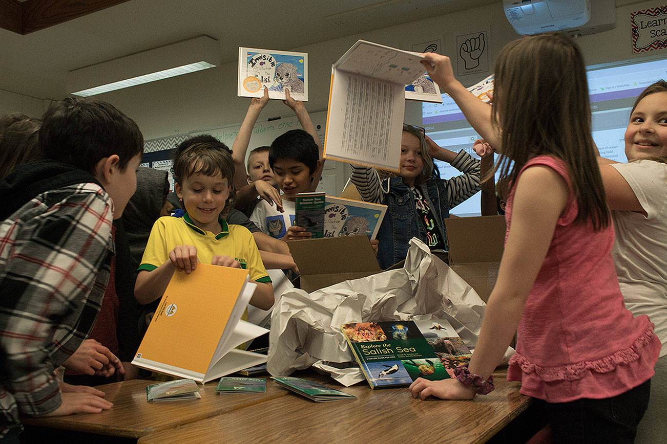 Photo by Brandon Taylor/Whidbey News-Times                                John Del Prete’s fourth-grade class tears into the box that has their published book “Invisible Pollution in the Salish Sea.”