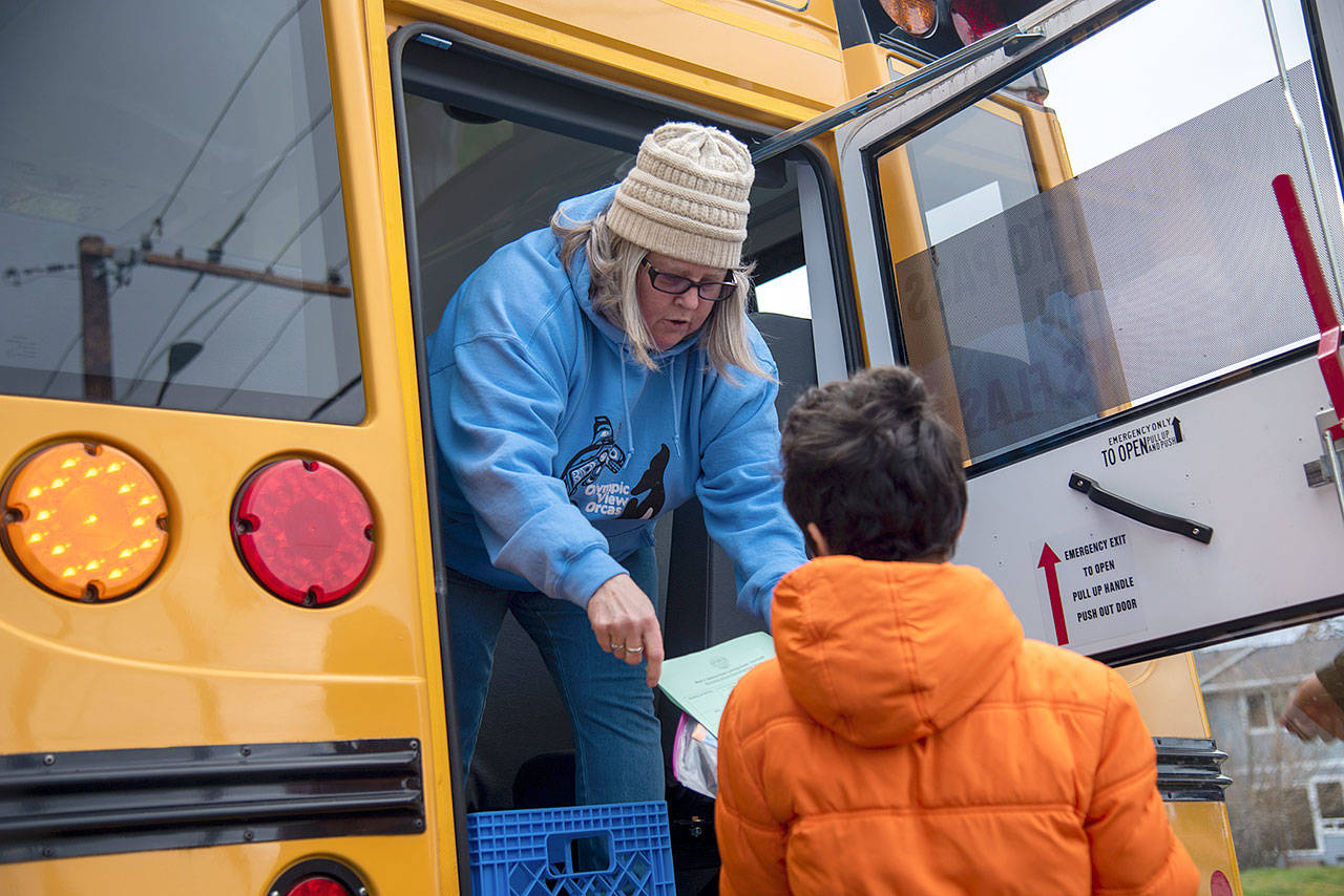 Photo provided                                Fran Leukhardt hands out food and educational materials from an Oak Harbor School District bus.