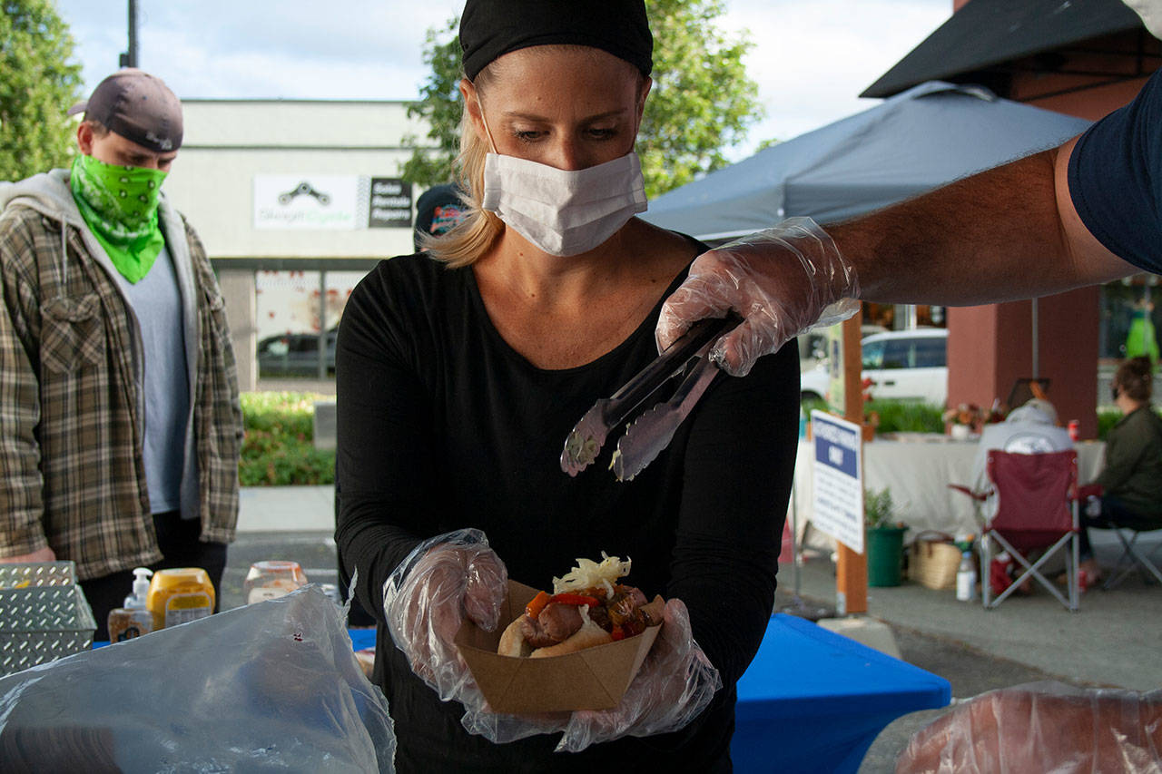 Julianne Blynn prepares a War Pig hot dog for customers during the Open Air Thursdays. Photo by Brandon Taylor