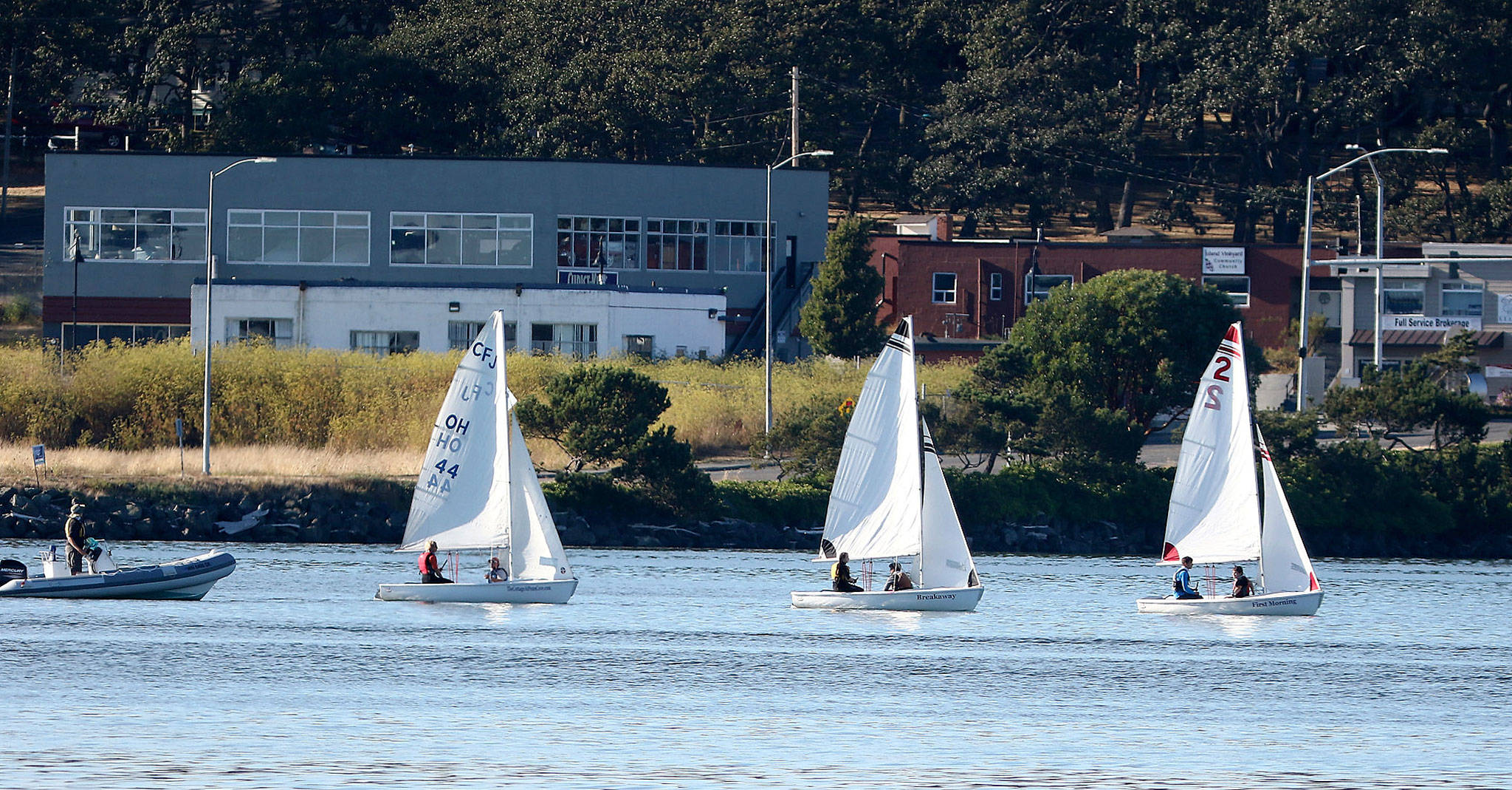 New Wildcat Sailing coach Shawn O’Connor, left, instructs his team during a recent practice. (Photo by John Fisken)