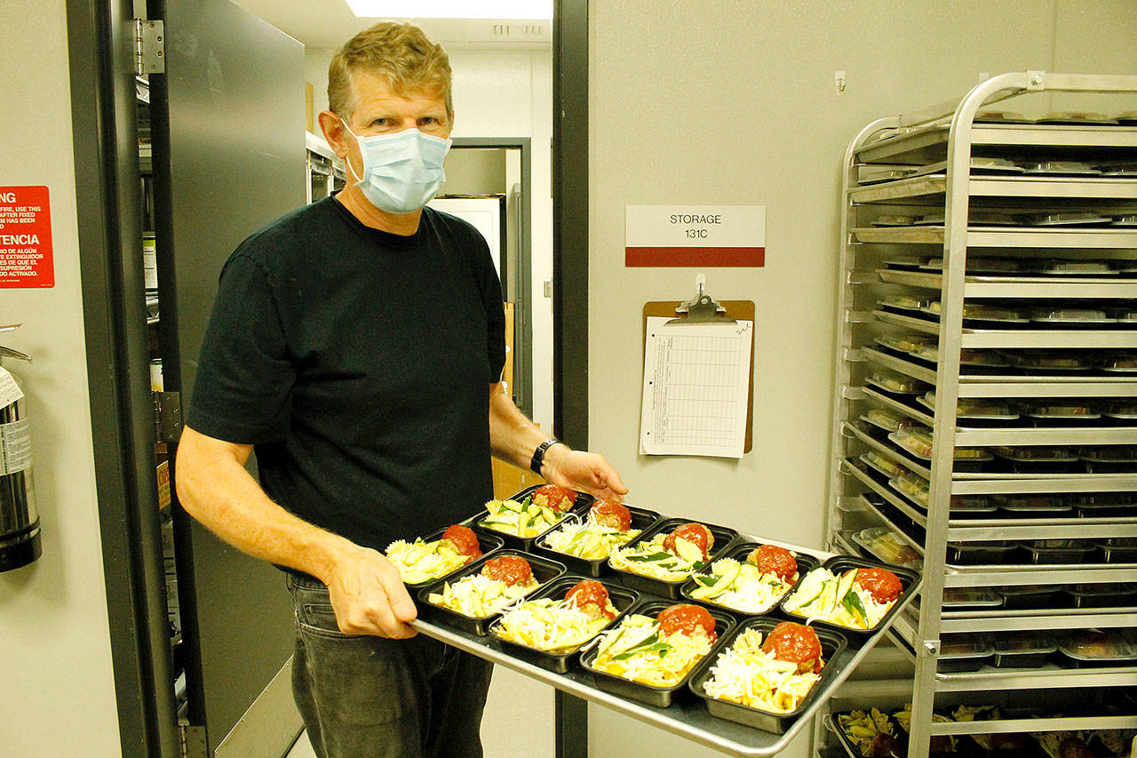 Andreas Wurzrainer, chef and director of the Coupeville School District’s Connected Food Program, lifts a tray with pasta, meatloaf and zucchini. Photo by Kira Erickson/Whidbey News-Times