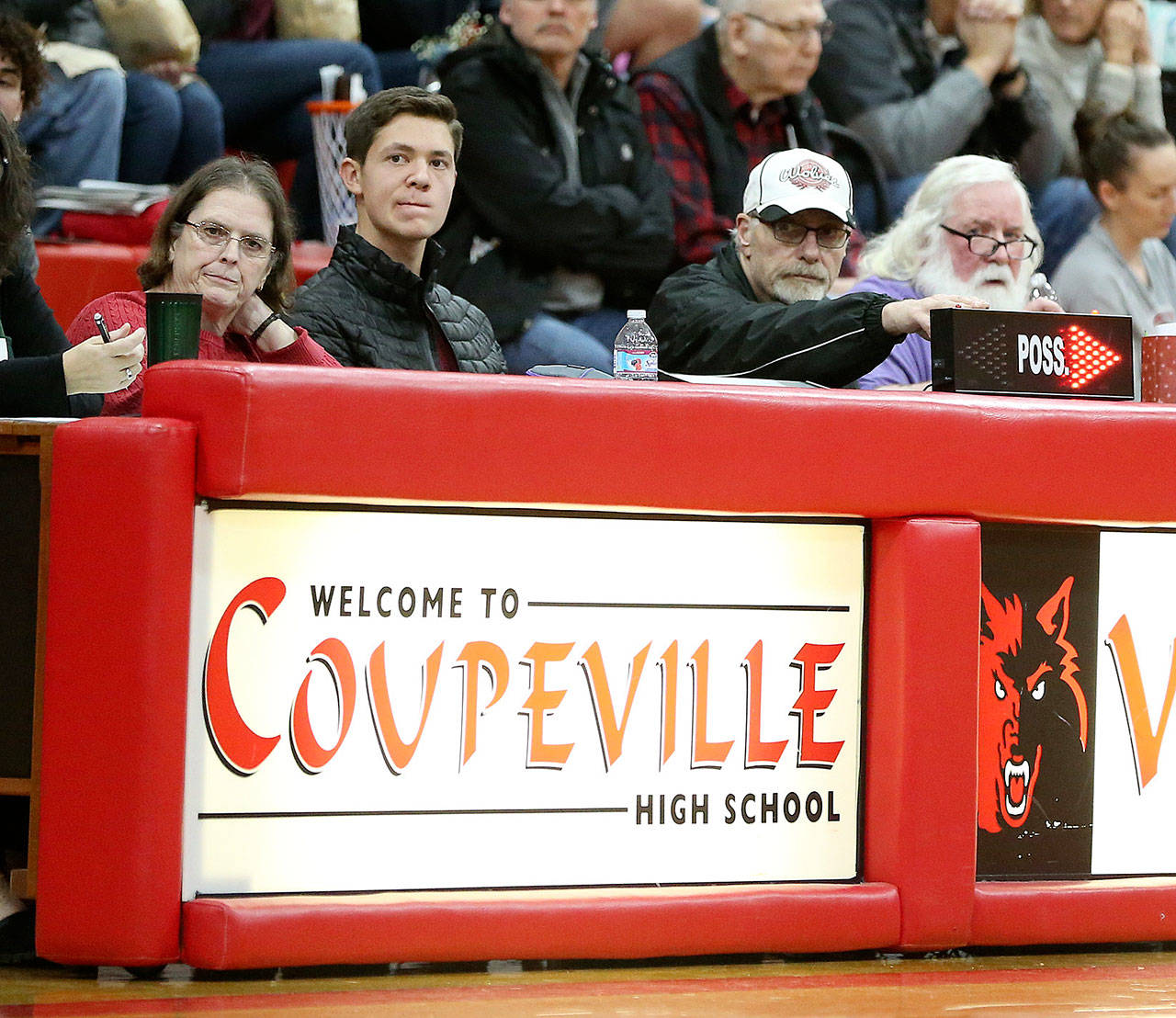 June Mazdra, left, and her husband Marty, third from left, have worked at the Coupeville High School basketball score table for 25 years. (Photo by John Fisken)