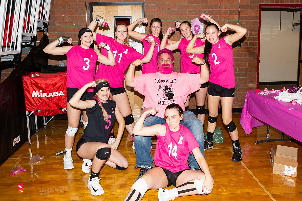 John Fisken enjoys interacting with the athletes he photographs. Above, he agreed to let the 2018 Coupeville High School volleyball team color his hair and beard pink for cancer awareness night. (File photo)