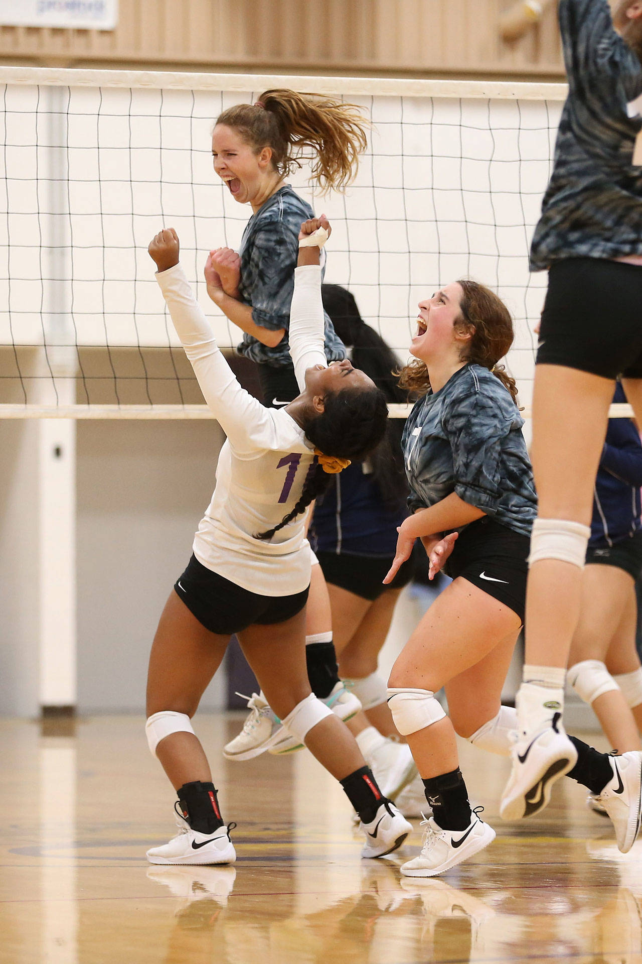 The Oak Harbor High School volleyball team celebrates a win in 2019. (Photo by John Fisken)