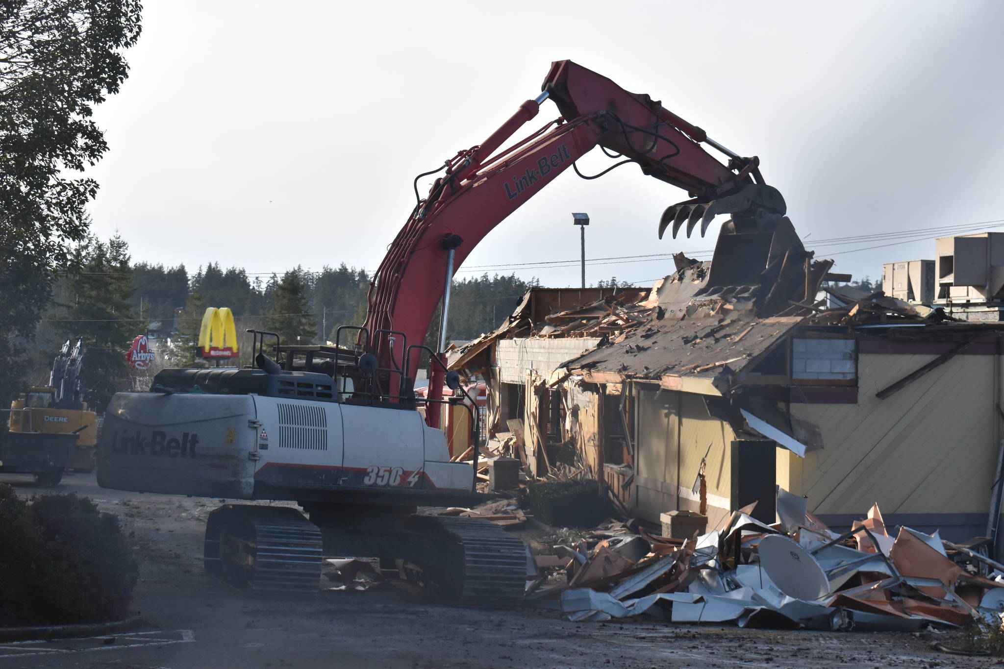 Photo by Emily Gilbert/Whidbey News-Times An excavator demolishes the Oak Harbor McDonald’s on Feb. 17. The madrona tree on the left side will be taken down to make way for the new building, although one woman tried to save it.