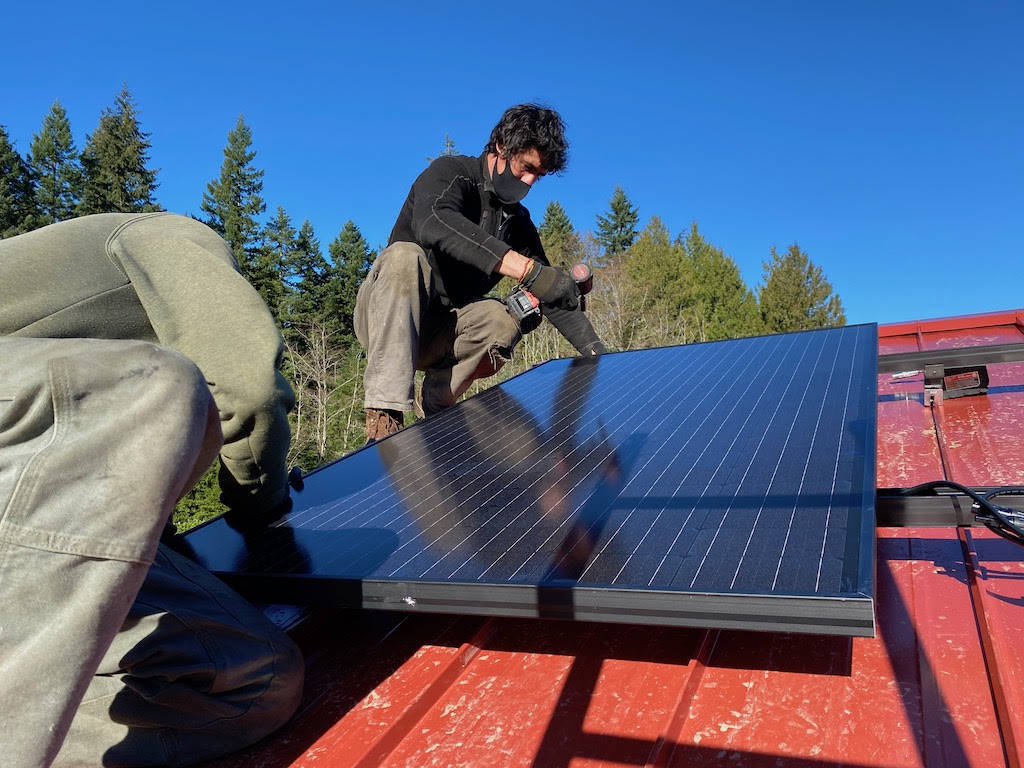 Adam Wundrow of Whidbey Sun and Wind installs a solar panel. Photo by Cary Peterson