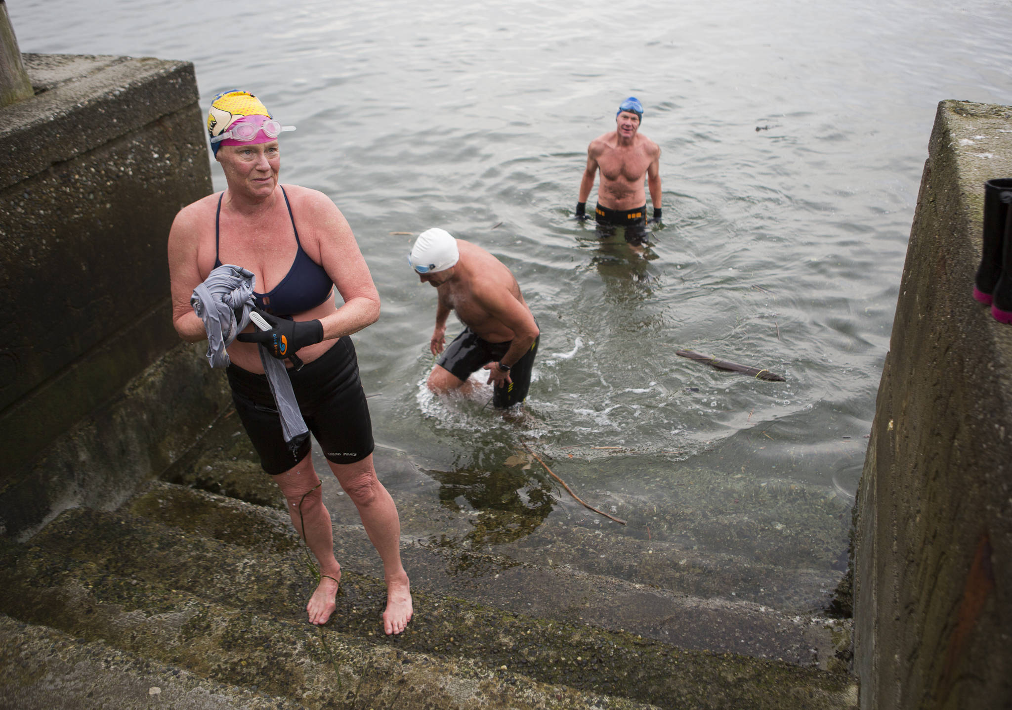 Photos by Olivia Vanni/The Everett Herald
Kristin Galbreaith, left, Joe Hempel and Brian McCleary make their way out of the water at Seawall Park in Langley. Photo below: Joe Hempel, right, and Kristina Galbreaith finish their swim from Seawall Park on Friday, Jan. 29,