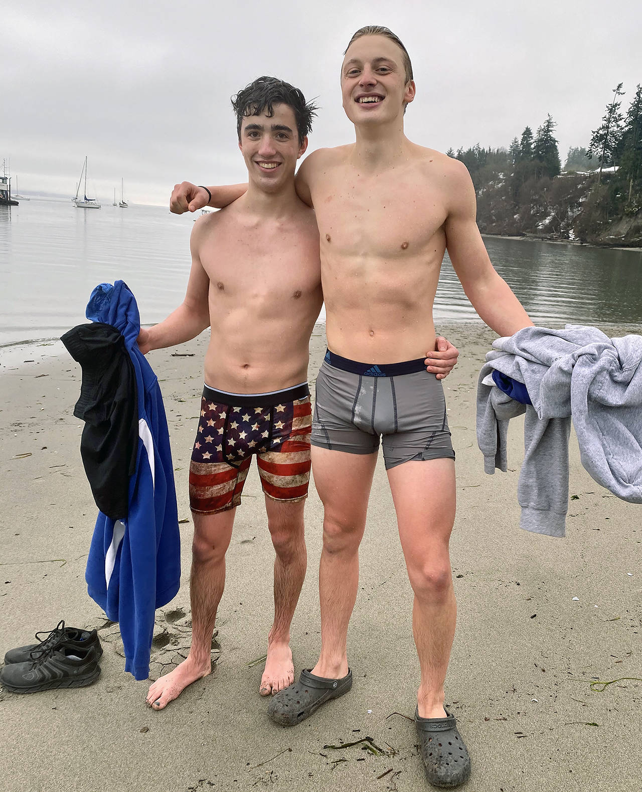 Whidbey athletes Cooper Ullmann, 18, and Kai Fawcett, 17, shed their shorts and wear boxer briefs to dunk in the Sound. (Andrea Brown / The Herald)