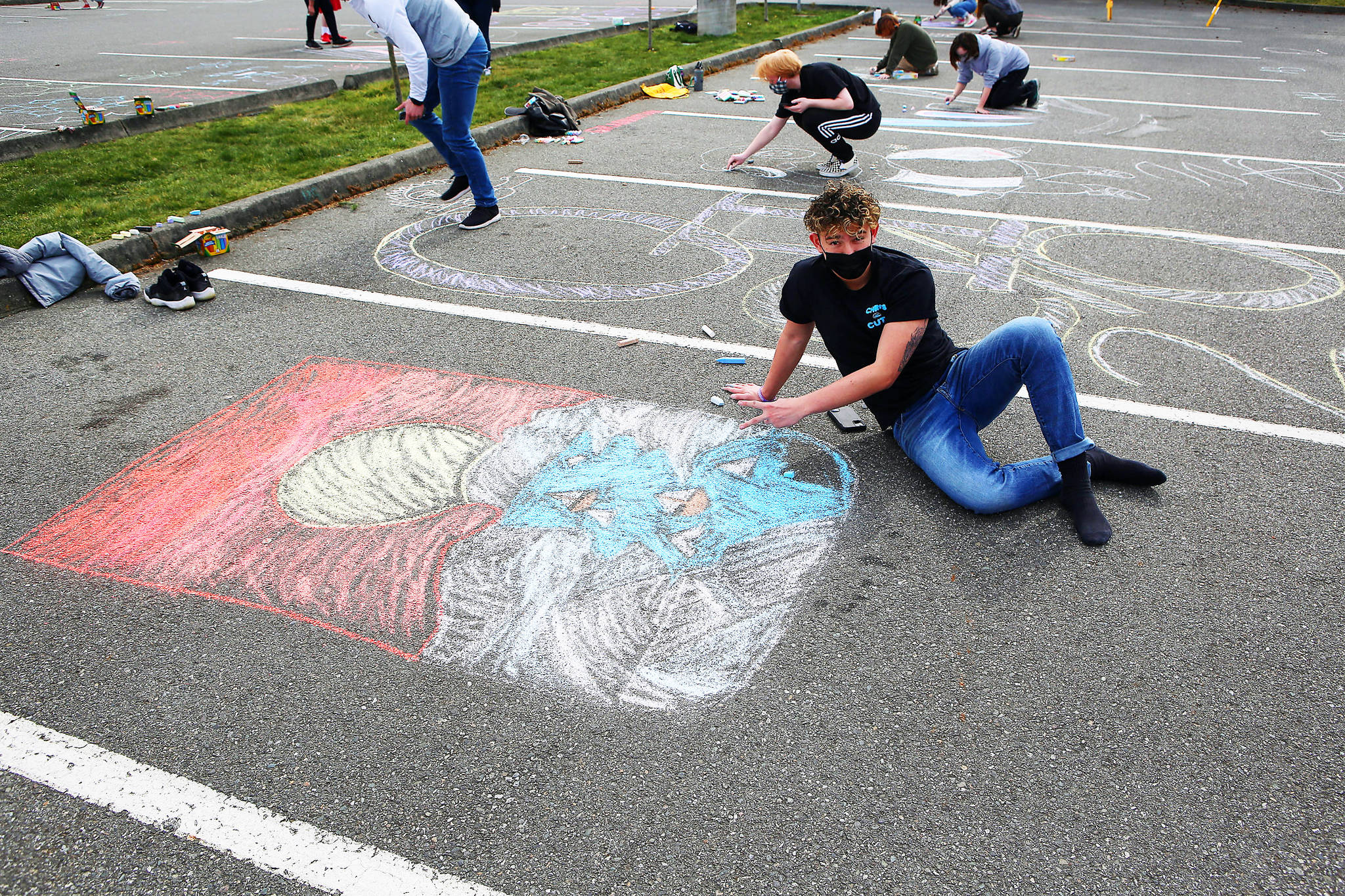 Photo by John Fisken
Christopher Hoppock was among 60 members of the Senior Class Council at Oak Harbor High School who took part in whimsical “Chalk It Up” fun and decorated the school parking lot. The event provided a “simple, intentional moment” for the class to get together safety and school officials predict it could be the start of a new tradition.