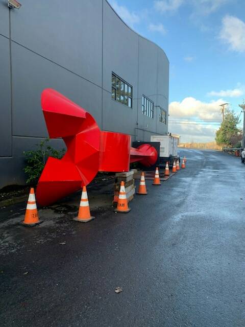 The “Angel de la Creatividad” sculpture is currently bright red and being stored on its side at a construction company’s property in Bellingham. Oak Harbor City Council members have not voted on whether to accept the gift of the art yet. Photo provided