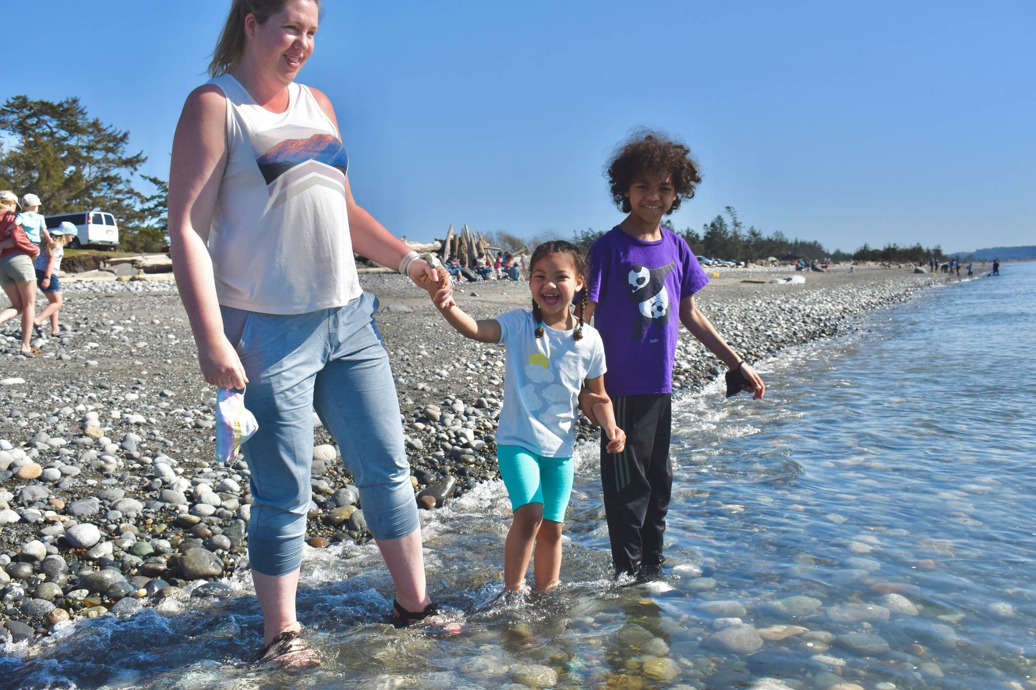 Four-year-old Tula Pierre-Louis and her brother, Iuri, play in the waves with mother Atty at West Beach in Deception Pass State Park. It’s the beginning of peak season for Washington’s most popular state park. (Photo by Emily Gilbert/Whidbey News-Times)