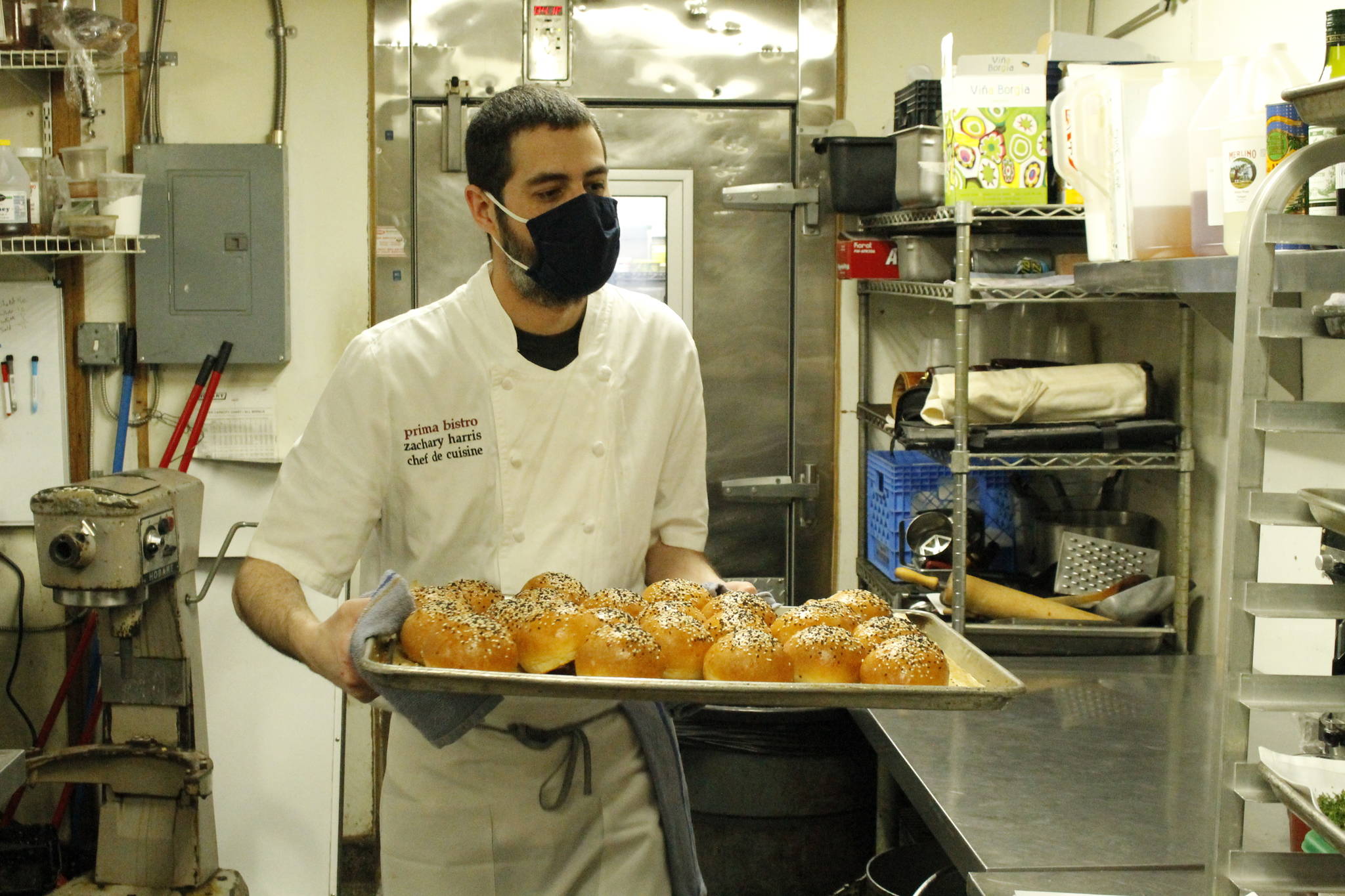 Head Chef Zachary Harris transports a pan of freshly baked buns in Prima Bistro’s kitchen. The Langley restaurant, like many other businesses on Whidbey, is looking for more staff as the spring season ramps up. Photo by Kira Erickson/Whidbey News Group