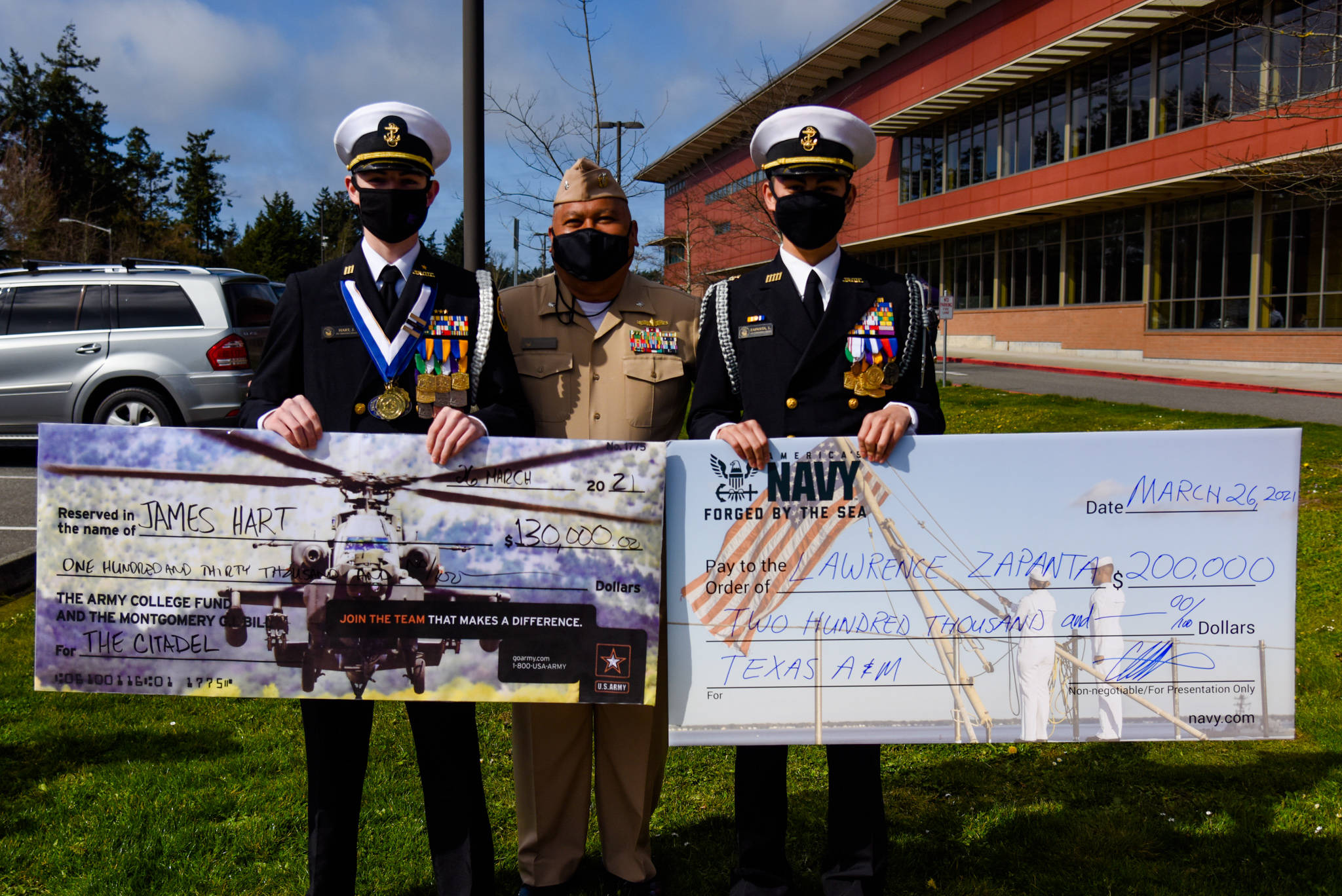 Oak Harbor High School seniors James Hart, left, and Lawrence Zapanta, right, with ret. U.S. Navy Cmdr. Vincent Quidachay, after they learned they had earned ROTC college scholarships. Photo by Oak Harbor Public Schools