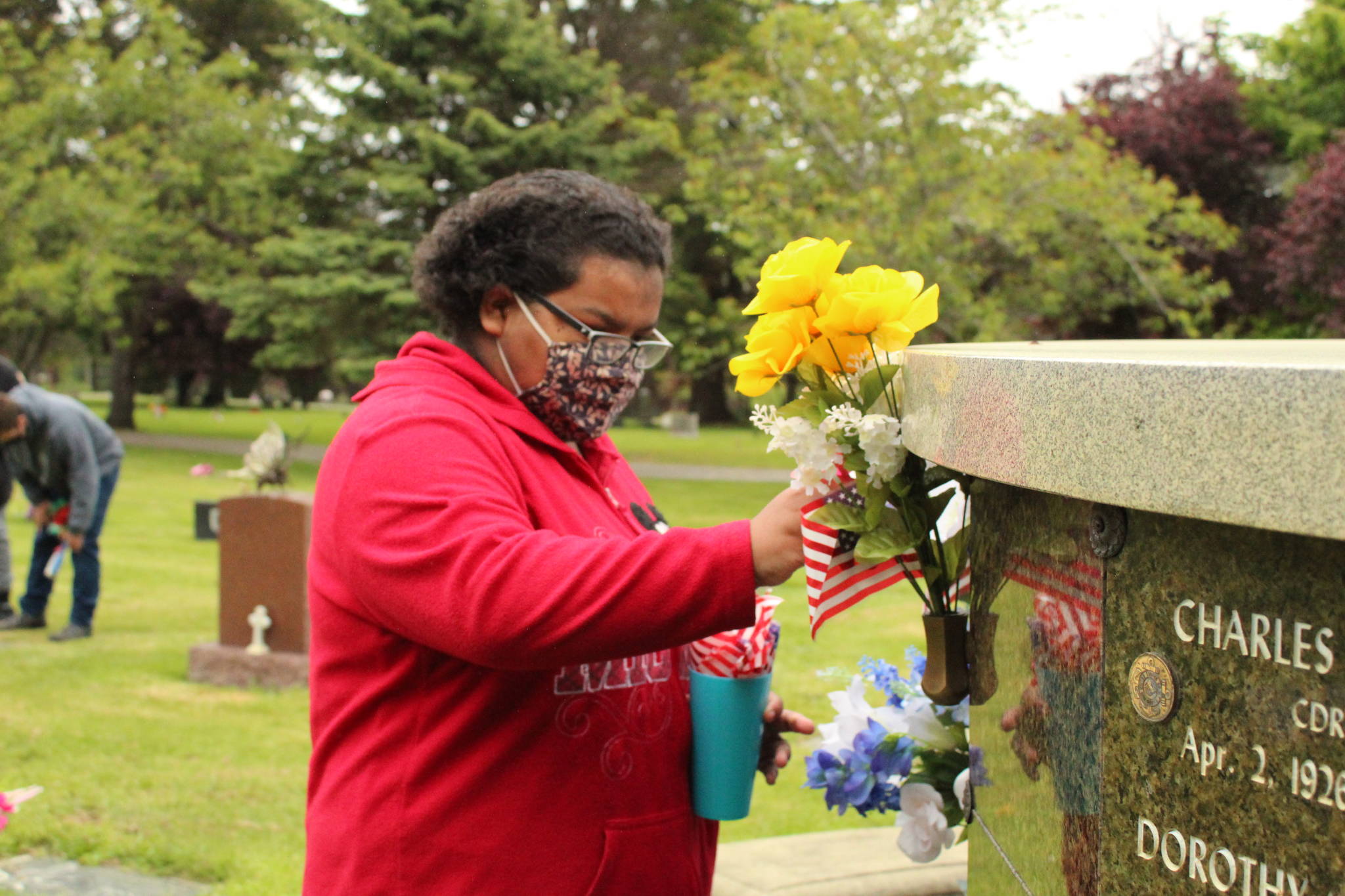 An Exceptional Academy student adorns a veteran's grave with an American flag at Maple Leaf Cemetery in Oak Harbor, May 17, 2021. (Photos by Karina Andrew/Whidbey News-Times)