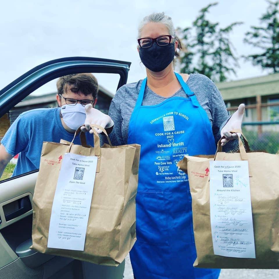Coupeville Farm to School school garden coordinator Zvi Bar-Chaim, left, and Julieanna Purdue, member of Cook for a Cause Planning Committee and farmer, deliver curbside pick-up meals at last year’s Cook for a Cause fundraiser. (Photo provided)