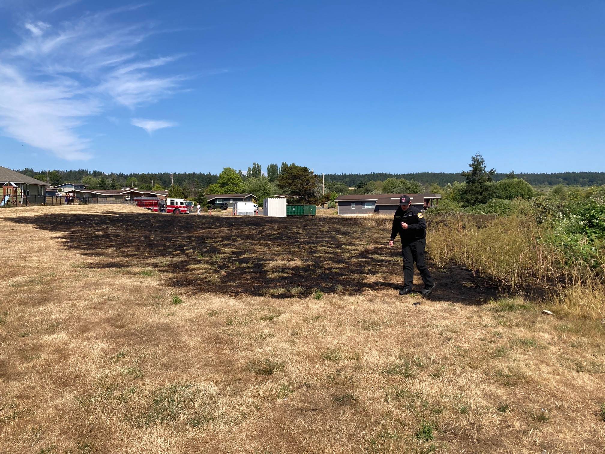 Navy photo
NAS Whidbey Fire Inspector Zach Walker looks at the damage of a small fire at a yard in military housing in Crescent Harbor Tuesday.
