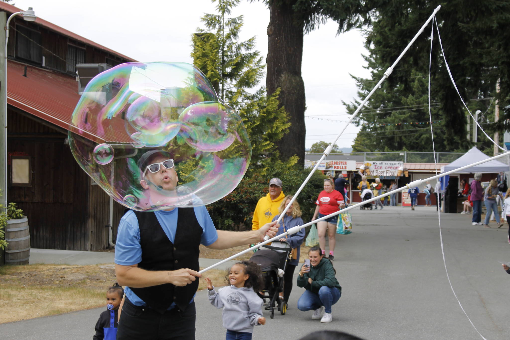 “Bubble Guy” Matt Henry blows a big bubble for children to chase at the Whidbey Island Fair Thursday. The performer is a regular fixture at the fair, which runs through Sunday. (Photo by Kira Erickson/South Whidbey Record)