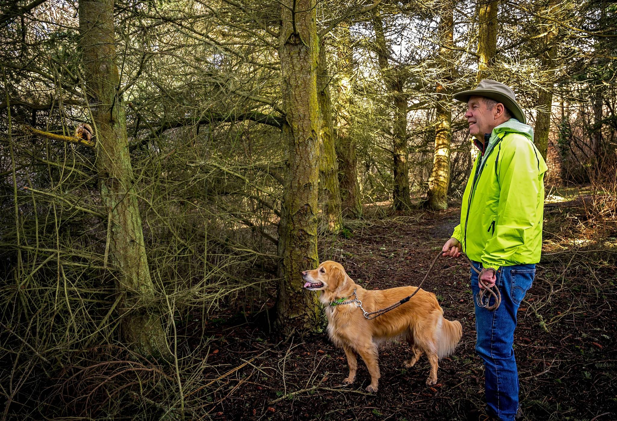 Bill Headridge and his dog Ginger appear delighted by the discovery of a Douglas squirrel during a late February walk at Admiralty Inlet Preserve, protected by the Whidbey Camano Land Trust. (Photo by Pam Headridge)