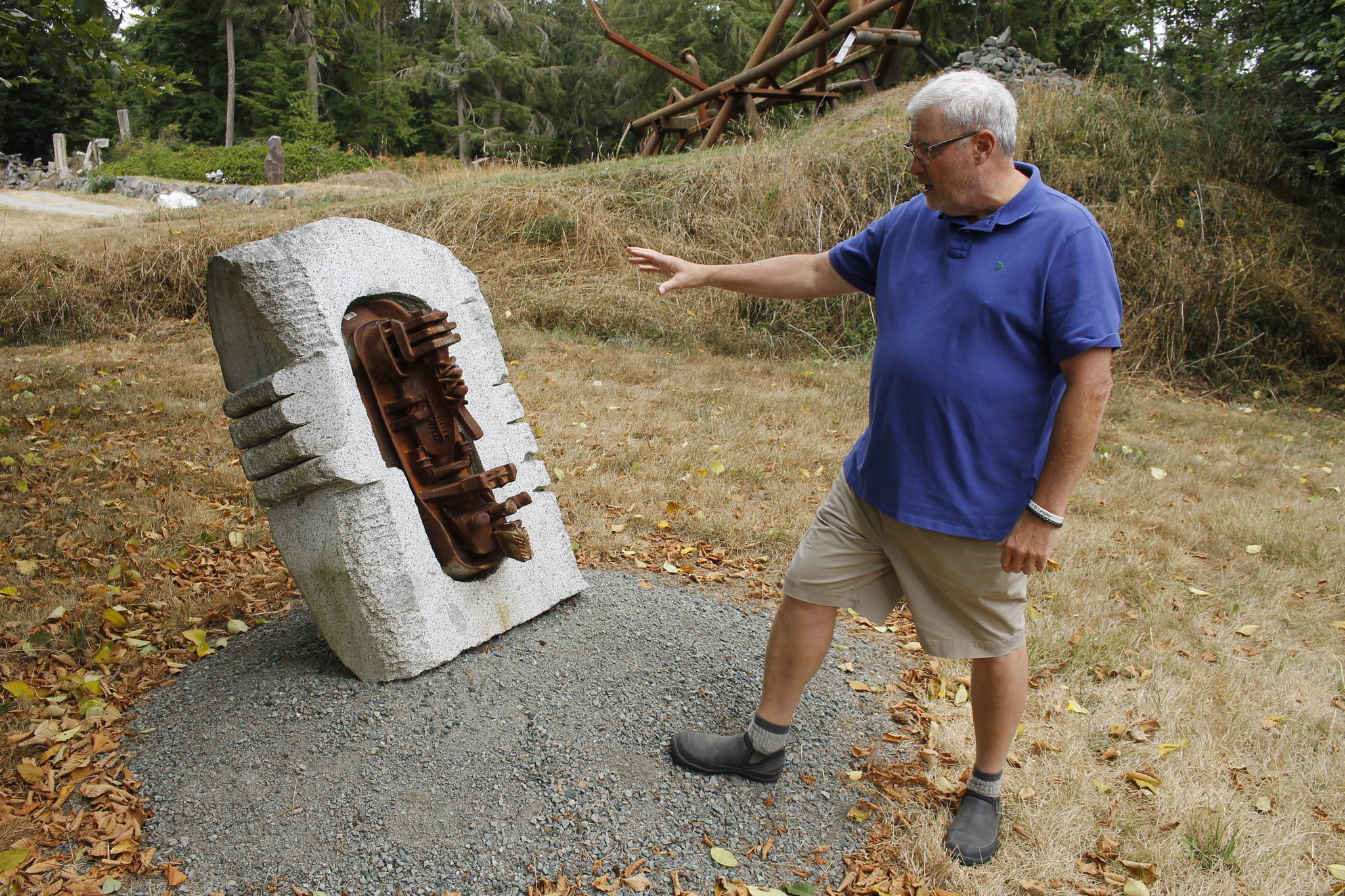 Burt Beusch, executive director of the Cloudstone Foundation, points out one of many sculptures in the Cloudstone Sculpture Park. (Photo by Kira Erickson/South Whidbey Record)