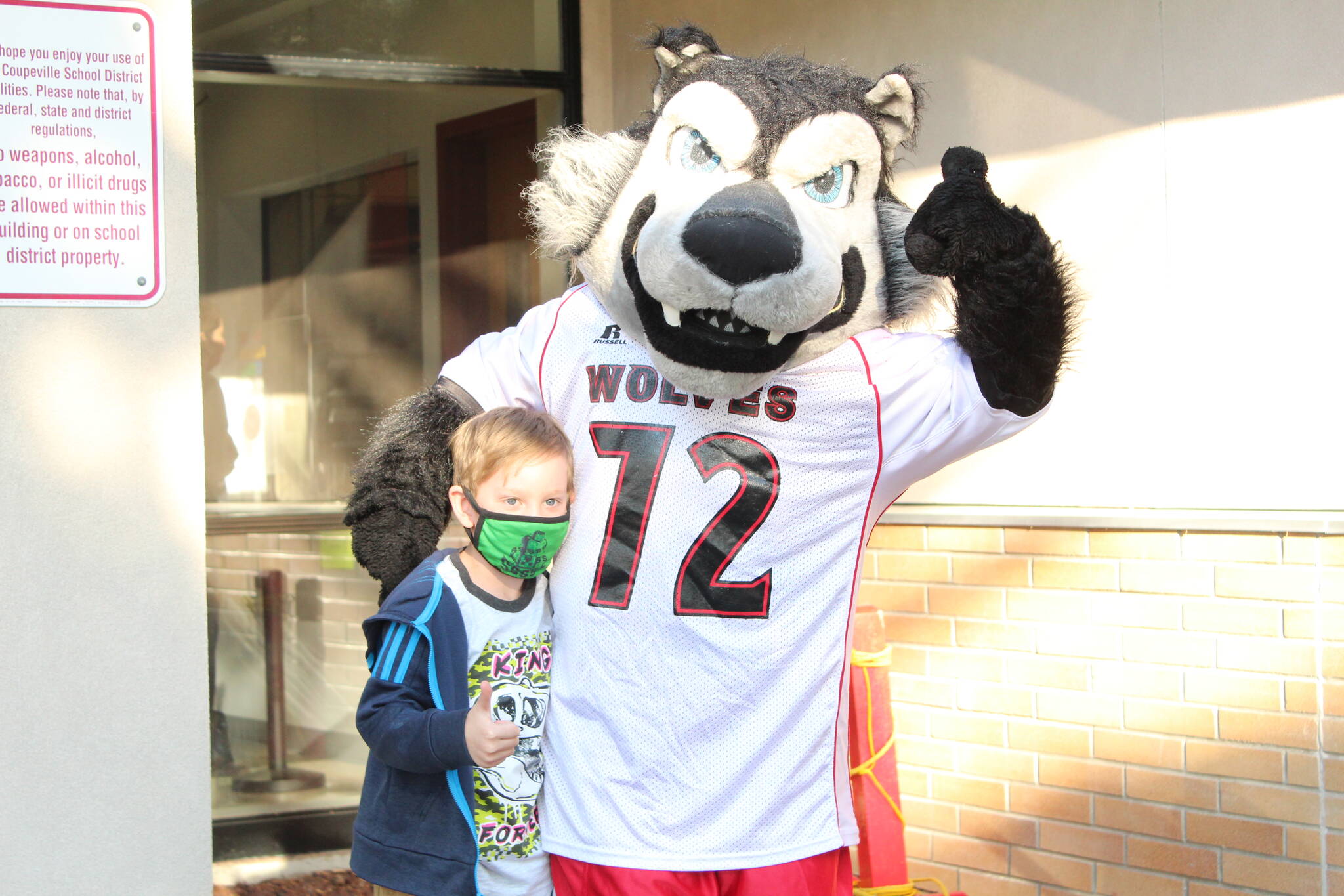 Quinton Freeman stops for a picture with the wolf pup mascot. (Photo by Karina Andrew/Whidbey News-Times)