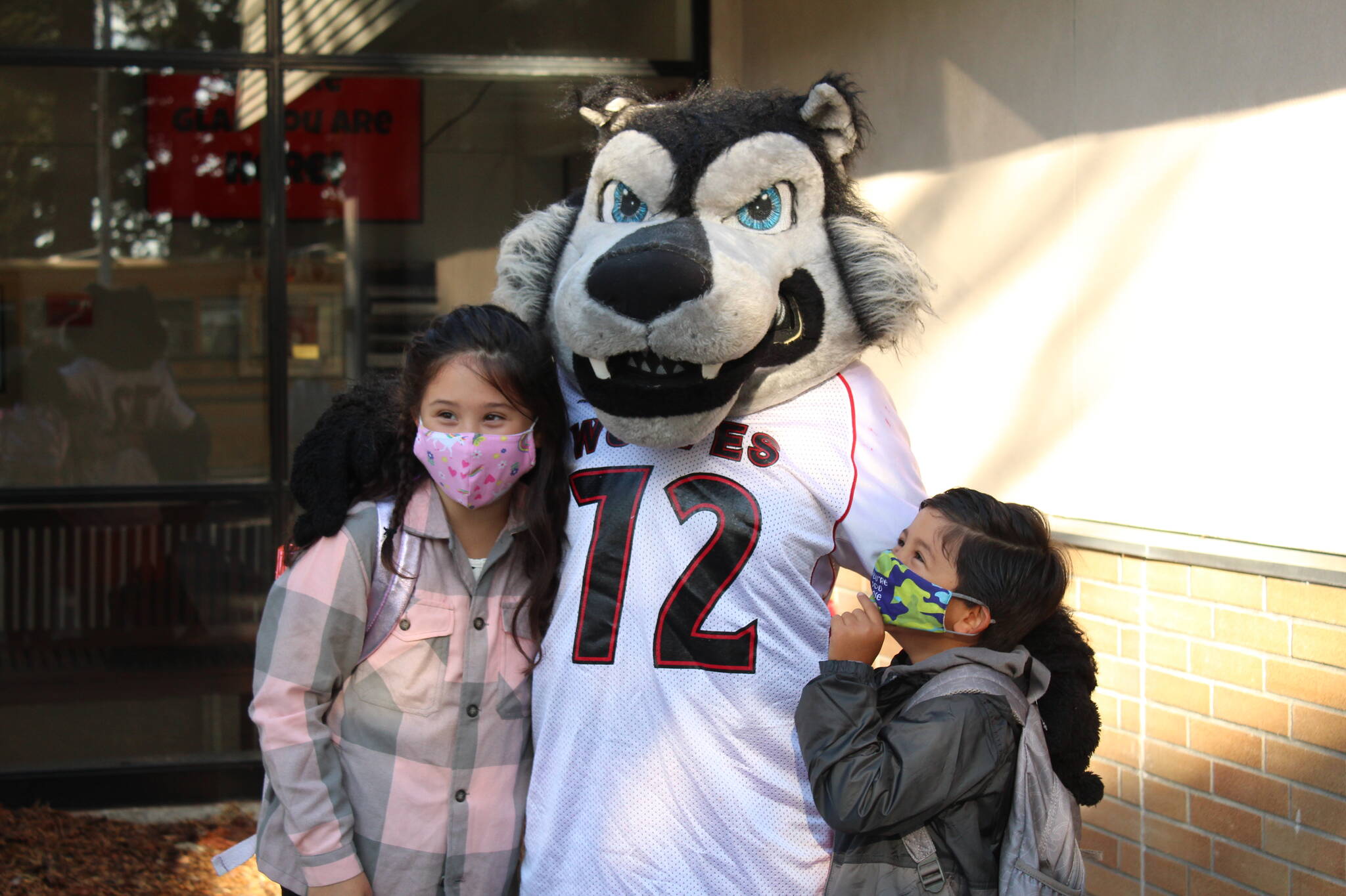 Isadora and Mateo Jimenez Campos stop for a picture with the wolf pup mascot. (Photo by Karina Andrew/Whidbey News-Times)