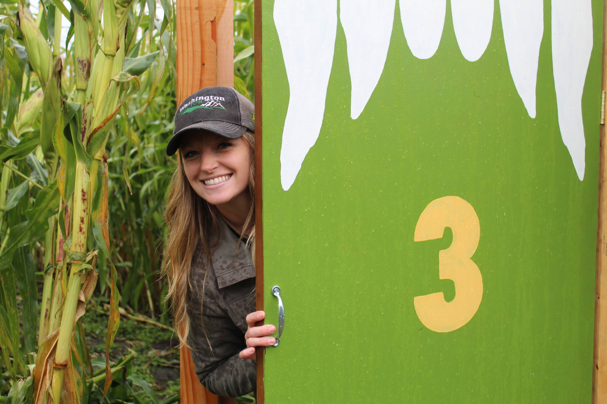Photo by Karina Andrew/Whidbey News-Times
The Whidbey Farm and Market corn maze begins with five, spooky doors leading into different sectors of the maze. Above, Shannon Hamilton peeks out from behind door number three. Enter if you dare!