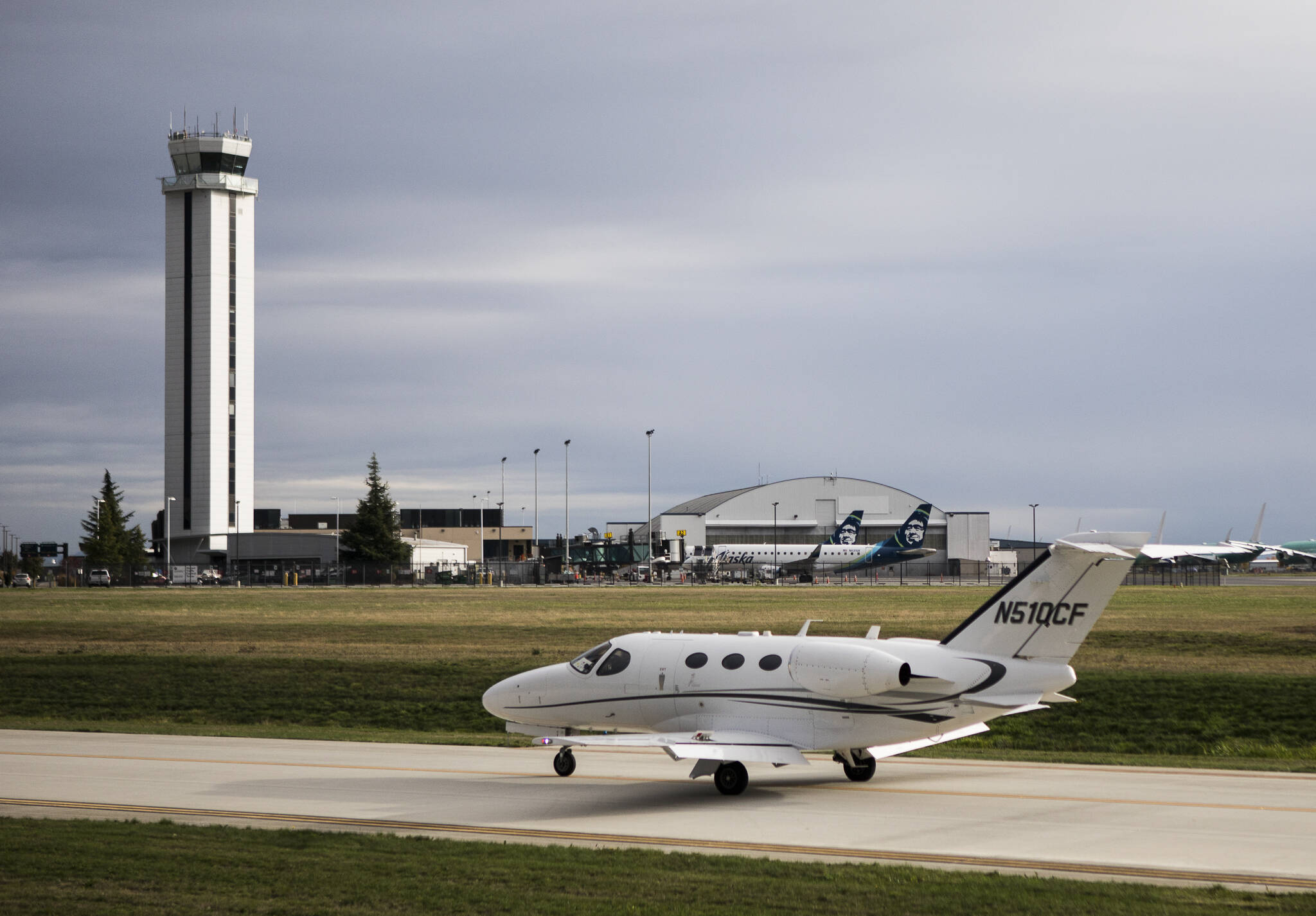 A private plane taxis past the Paine Field tower and passenger terminal on Wednesday in Everett. (Olivia Vanni / The Herald)