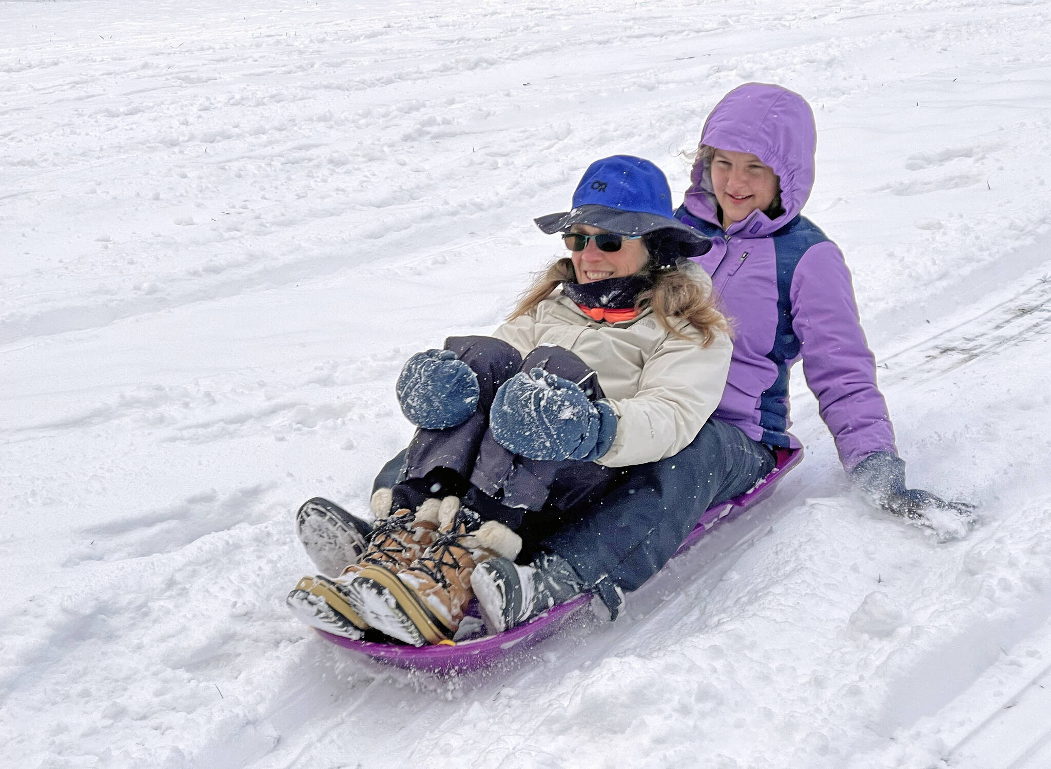 Photo by Scott Price
Karen Price, left, and Lydia Price sled down a hill in the backyard of their Coupeville home.