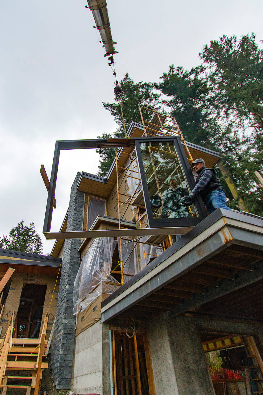 Photo by Dave Welton 
A construction crew prepares to install a window at a South Whidbey site.