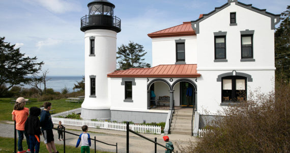 A group of children take a look at the restored Admiralty Head Lighthouse Thursday, April 7, 2022, near Coupeville, Washington. (Ryan Berry / The Herald)