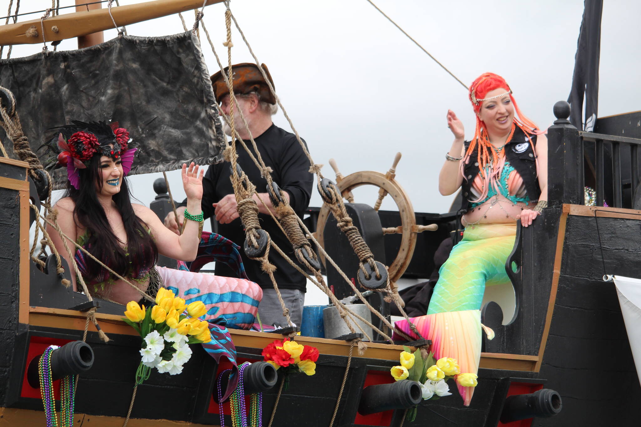 A couple of mermaids with the Whidbey Island Pirates ride by on a pirate ship. (Photo by Karina Andrew/Whidbey News-Times)