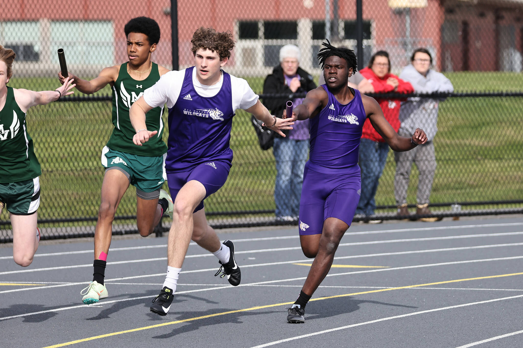 Photos by John Fisken
Sophomore Michael Johnson-Howard, right, passes the baton to junior Barrett Schmall during the 4 x 100 meter relay. The relay team took second place with a time of 45.37 seconds.