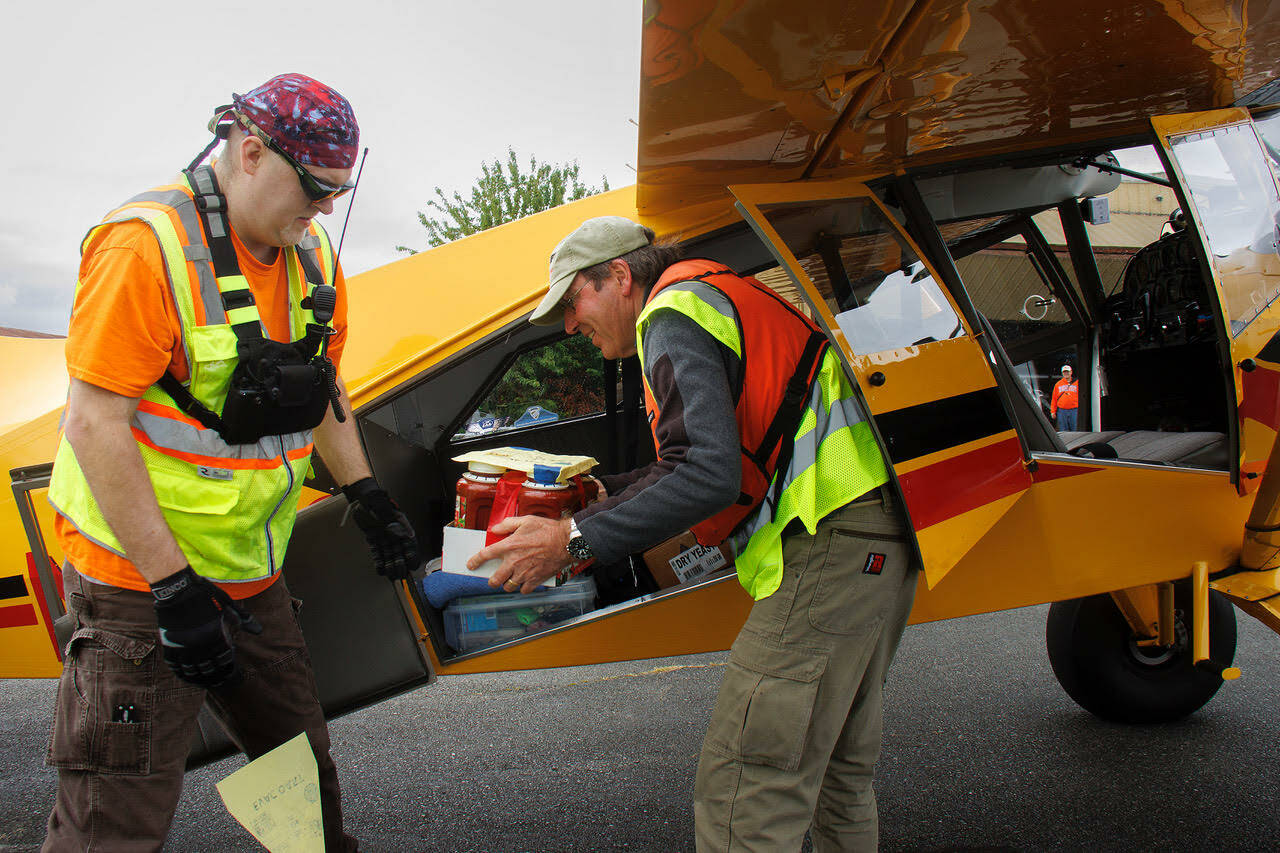 Volunteers unload food donations from an airplane. (Photo By David Welton)